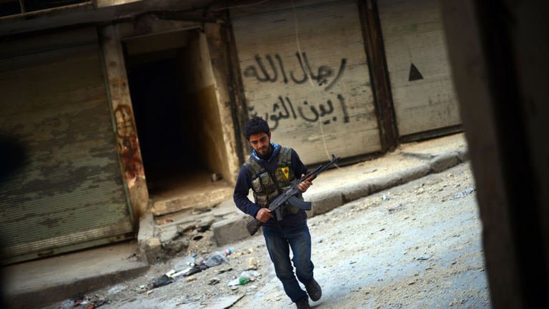 A Kurdish rebel fighter runs to avoid government forces' snipers in the northern Syrian city of Aleppo on April 14, 2013. Jihadist groups linked to Al-Qaeda have taken hostage around 200 Kurdish civilians after violent clashes with Kurdish fighters in two villages of eastern Syria, a monitoring group said.