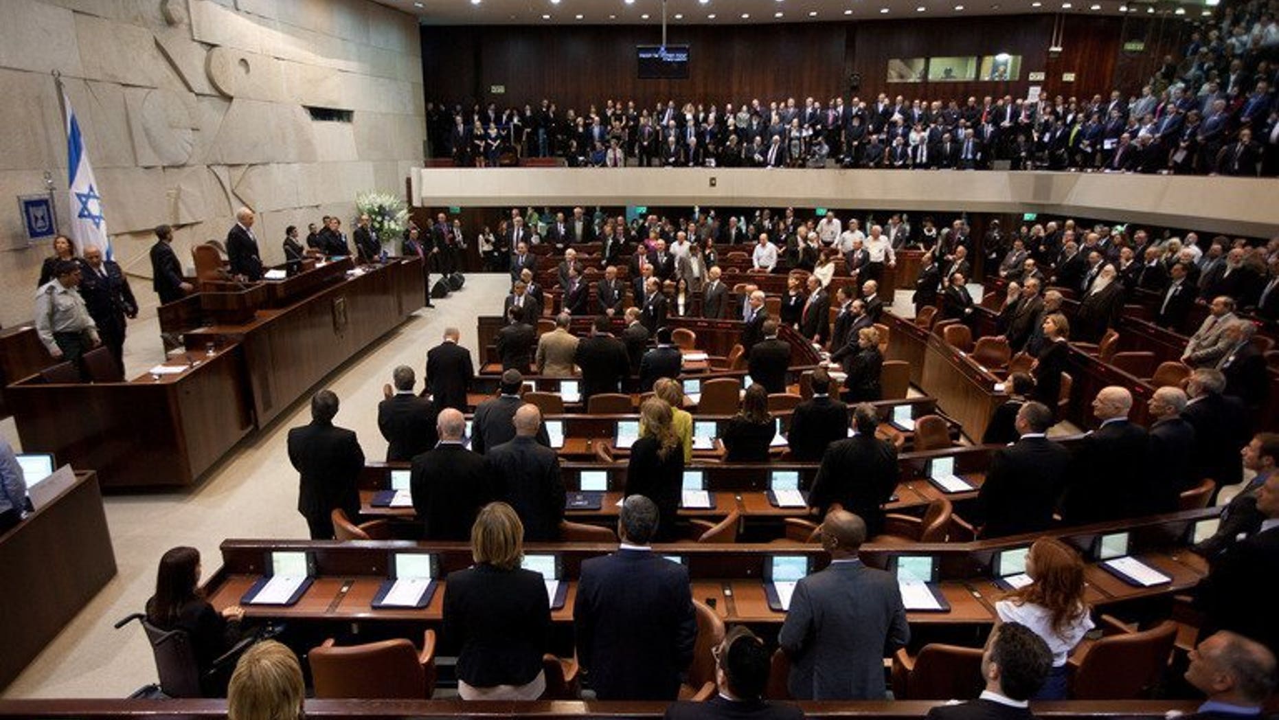 Israeli lawmakers stand during a swearing-in ceremony at the Knesset in Jerusalem, on February 5, 2013. Israel's parliament has taken the first tentative steps towards reining in the country's extreme form of proportional representation in a bid to make governments more stable.