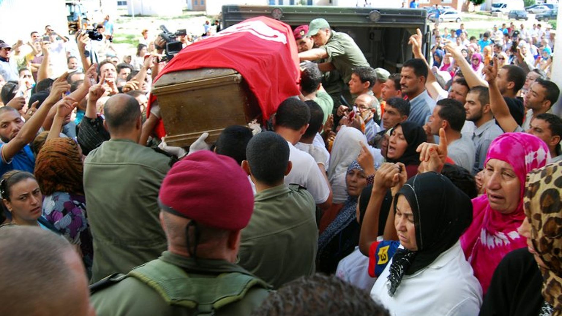 Tunisian soldiers carry the coffin, draped in the Tunisian flag, of one of the eight soldiers that was slain by militants in an ambush near the Algerian border, as they leave the hospital in Kasserine on July 30, 2013. Algeria's army has reinforced its forces along the eastern border with Tunisia, Interior Minister Daho Ould Kablia said on Thursday, days after the killing.