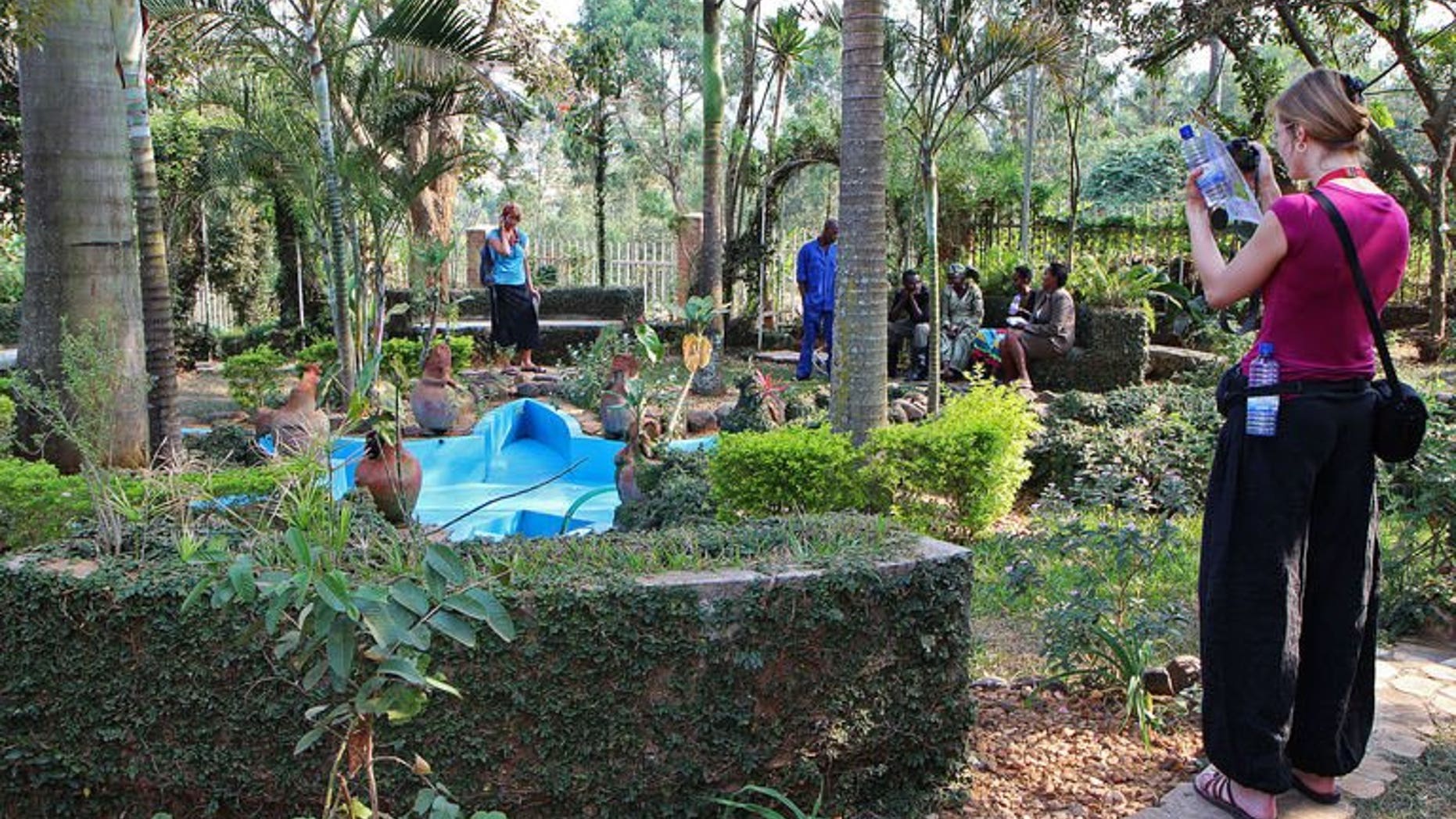A tourist takes a picture at the Rwanda Genocide memorial in Kigali on July 23, 2013. Rwanda, which has staged a remarkable recovery in the two decades since the 1994 genocide, has opened visitors' eyes to its past by putting its genocide memorials on the tourist circuit, alongside its iconic mountain gorillas.