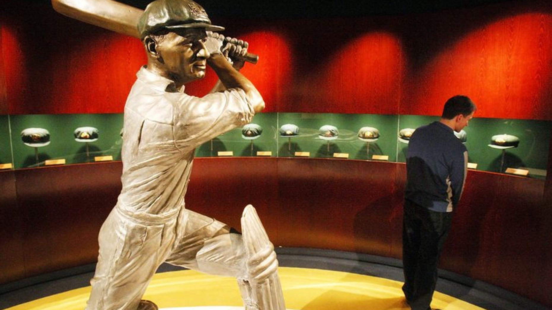 A statue of Australian cricketing great Don Bradman is ringed by Baggy Green caps worn by the famous cricketer, at the Sports Museum at the MCG in Melbourne, on June 2, 2008. A bat used by Bradman and signed by his 1948 "Invincible" team is expected to fetch up to Aus$20,000 at auction this month, an auctioneer said on Friday.