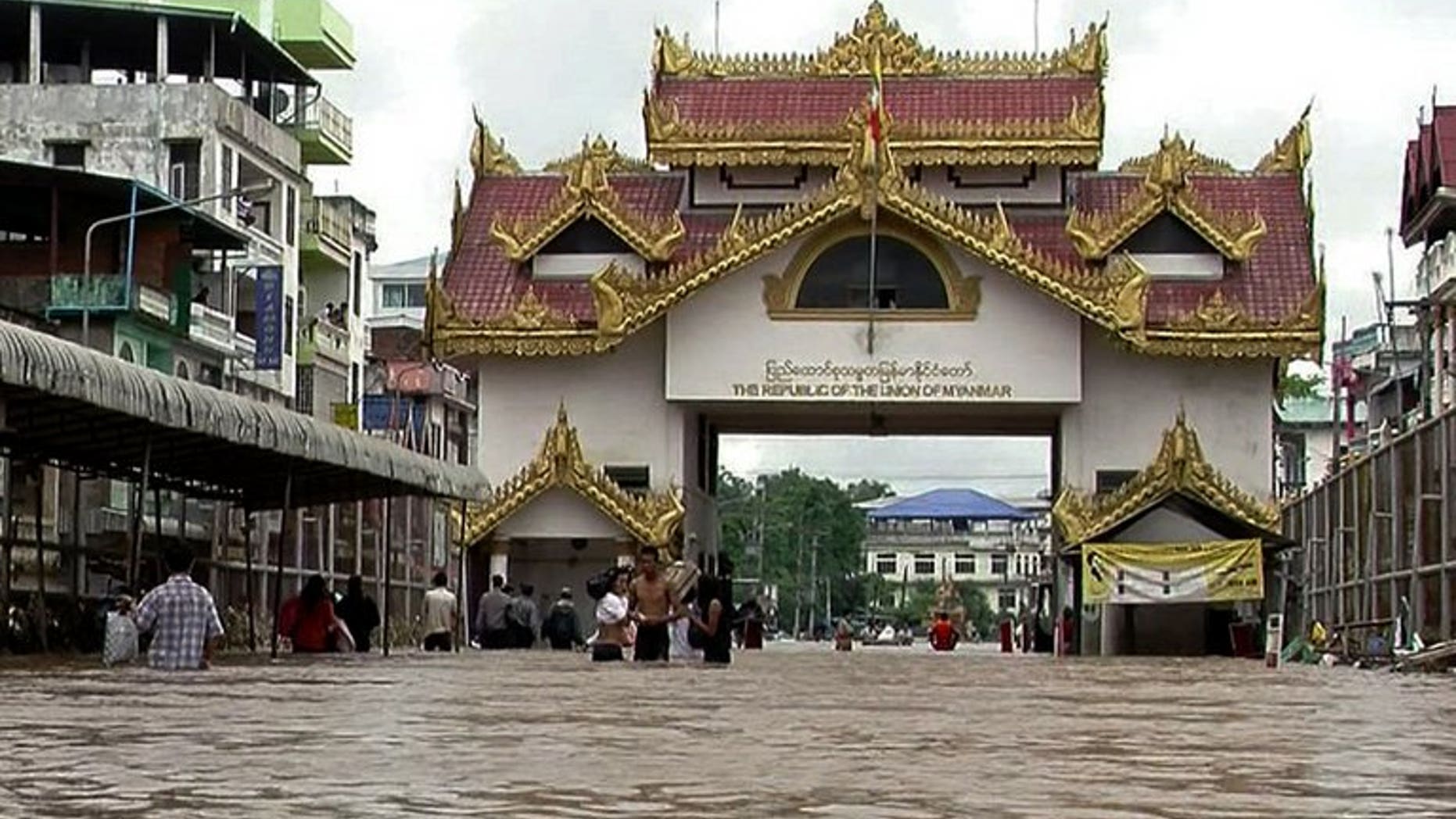 Villagers walk through flood waters in Myawaddy town, on July 31, 2013. Tens of thousands of people were sheltering in relief camps in eastern Myanmar after flash floods swept the region leaving three dead, state media said on Friday, warning of more heavy rain to come.