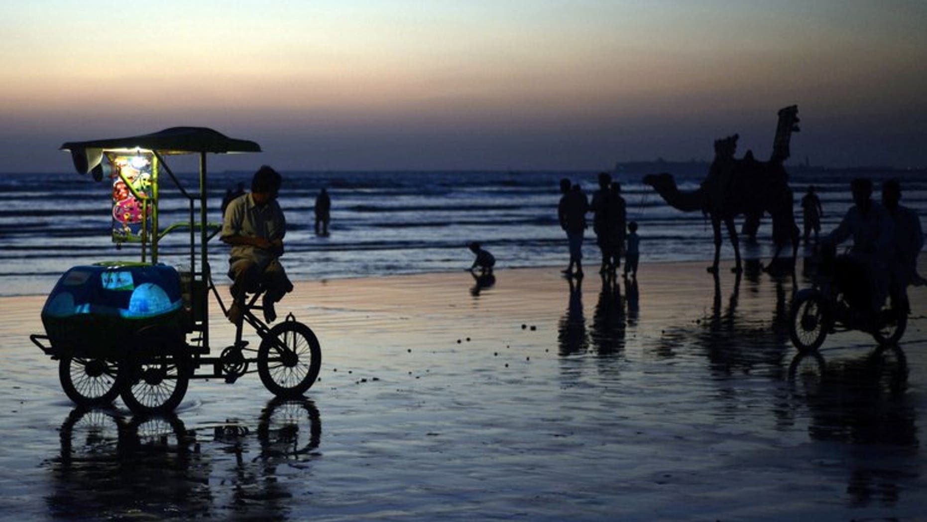 In this file photo, people are seen gathering on Sea View Beach during sunset in Karachi, on November 5, 2012. A charismatic Muslim preacher criticised for giving out babies to childless couples live on prime-time Pakistani television denies he is crudely seeking top ratings and insists he is spreading charity.