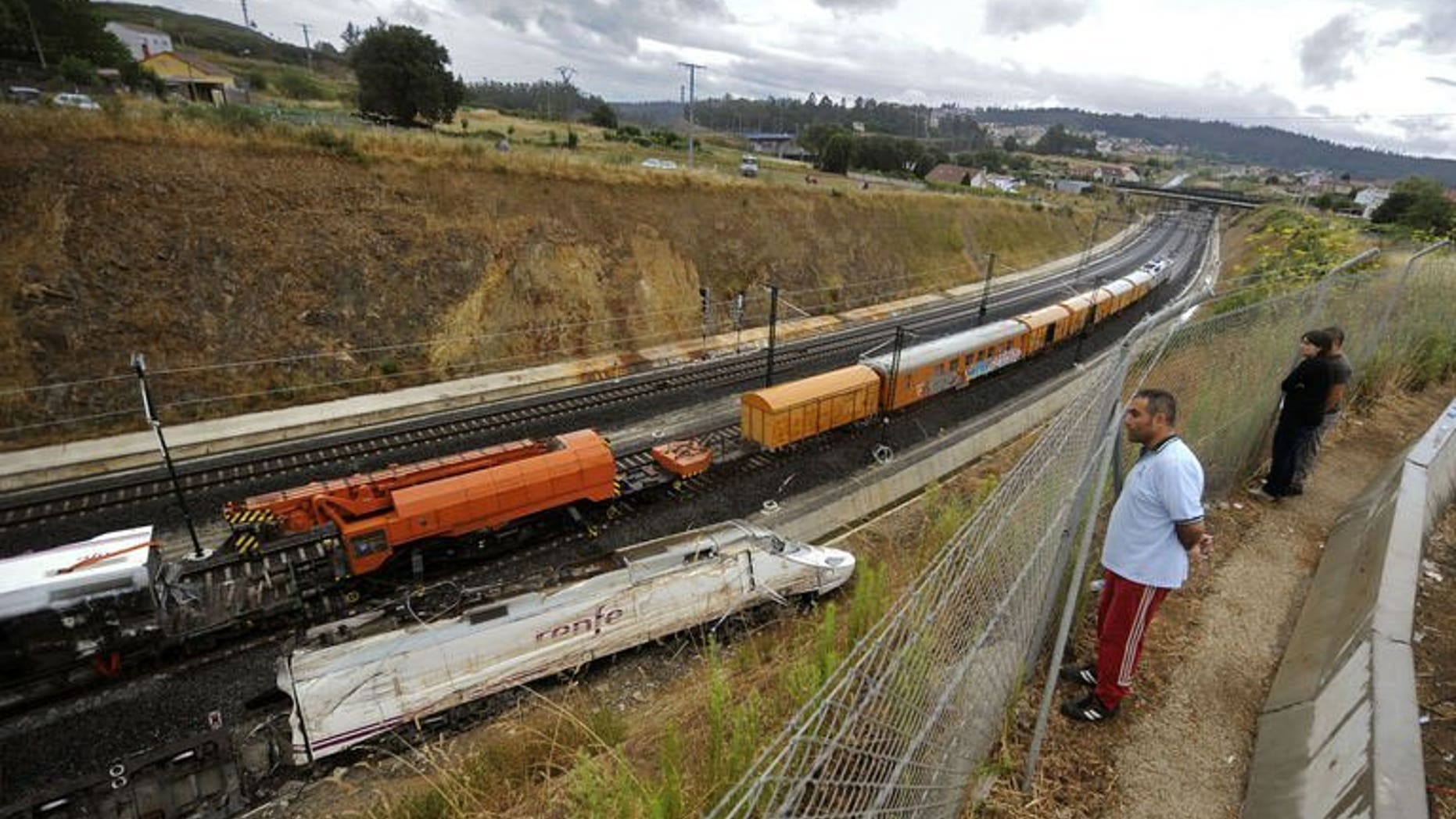 People look at part of a train that crashed in Angrois, near Santiago de Compostela, on July 27, 2013. The Spanish train was hurtling around a curve at 179 kph (111 mph), more than twice the speed limit, when it leapt off the tracks in a disaster that killed 79 people, a report on the contents of the "black box" recorders showed.