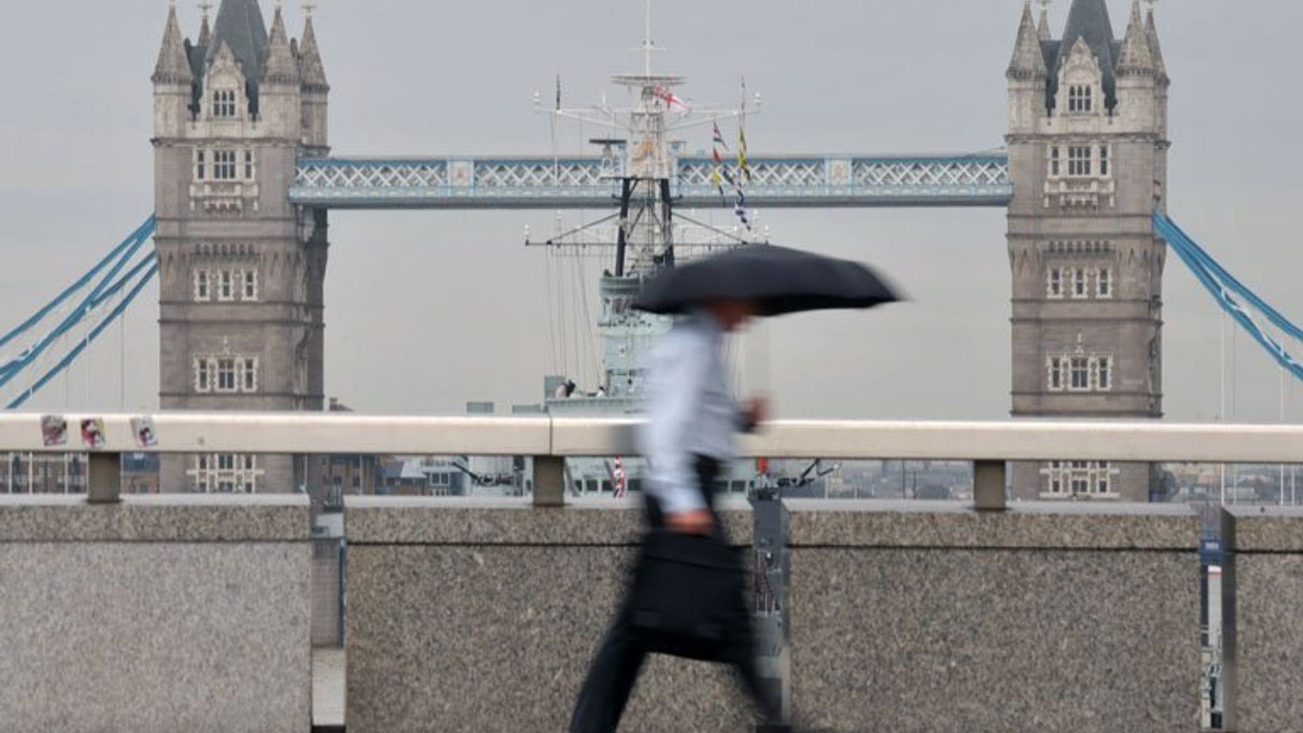 A city worker walks over London Bridge in central London. London shares closed lower on Friday as markets tumbled on weak US nonfarm payroll employment figures, with sharp drops in William Hill and Smiths Industries accentuating the fall, dealers said.