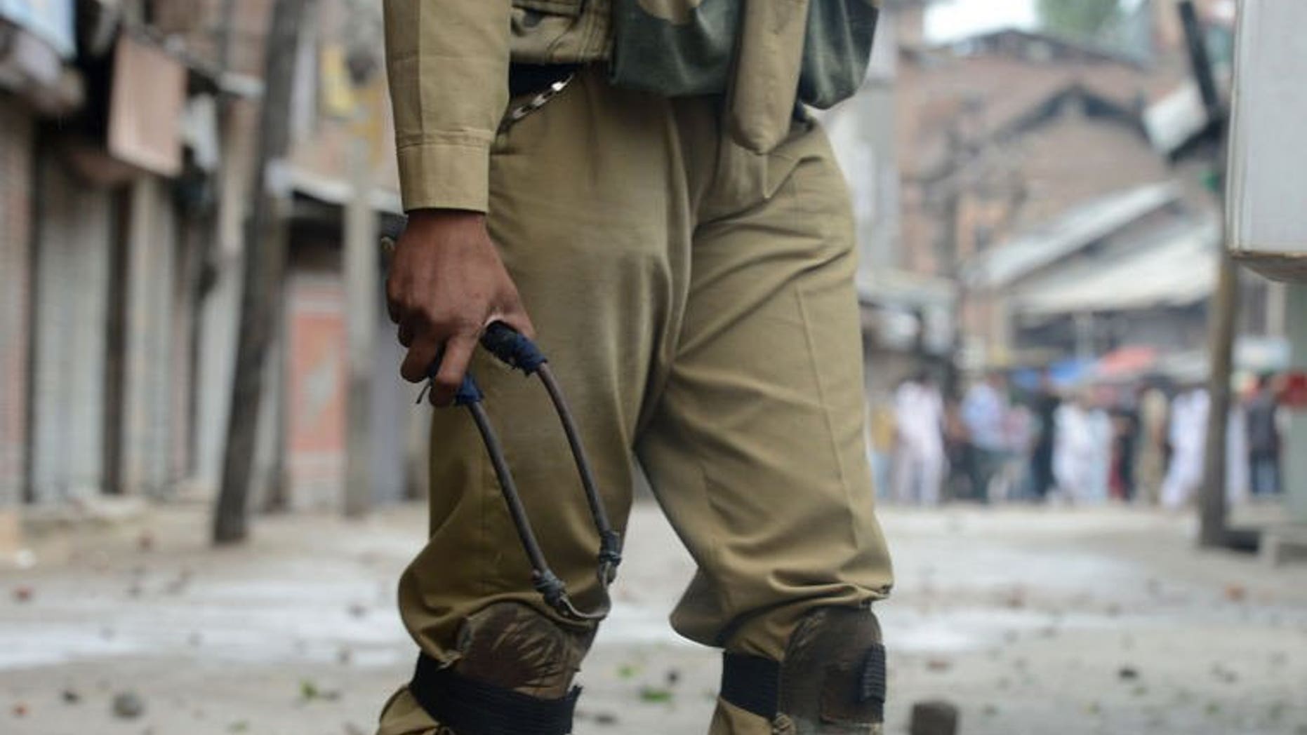 An Indian policeman holds a slingshot during clashes in downtown Srinagar on August 2, 2013. The Indian army said Friday it had killed 12 suspected militants in Kashmir in a forested area along the de facto border that divides the territory between India and Pakistan.