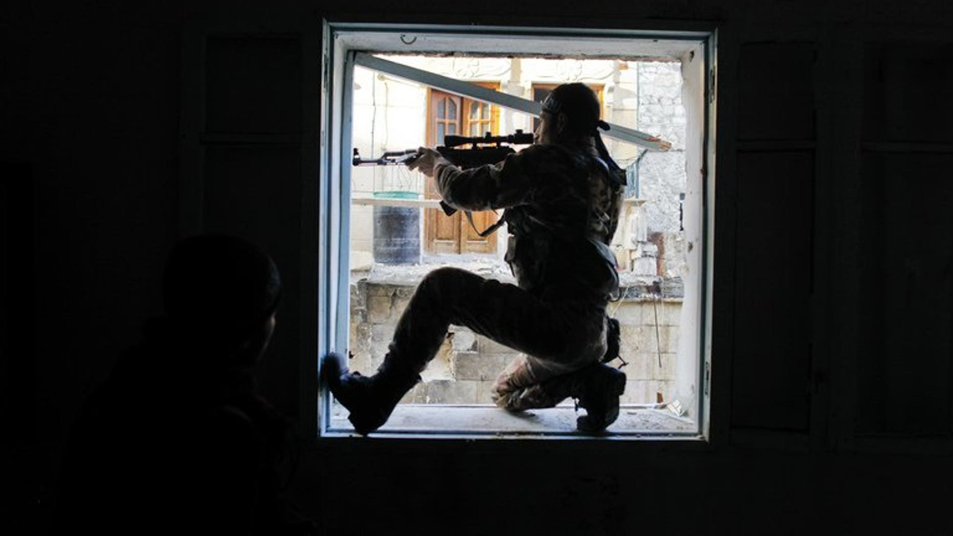 A Syrian rebel aims at a regime forces during clashes in the Karmel al-Jabl district of Aleppo, on December 6, 2012. Two Islamist Lebanese-Swedish brothers who left their Scandinavian home for Lebanon, have died fighting alongside Syrian rebels in Homs province, their cousin and a local cleric tell AFP.