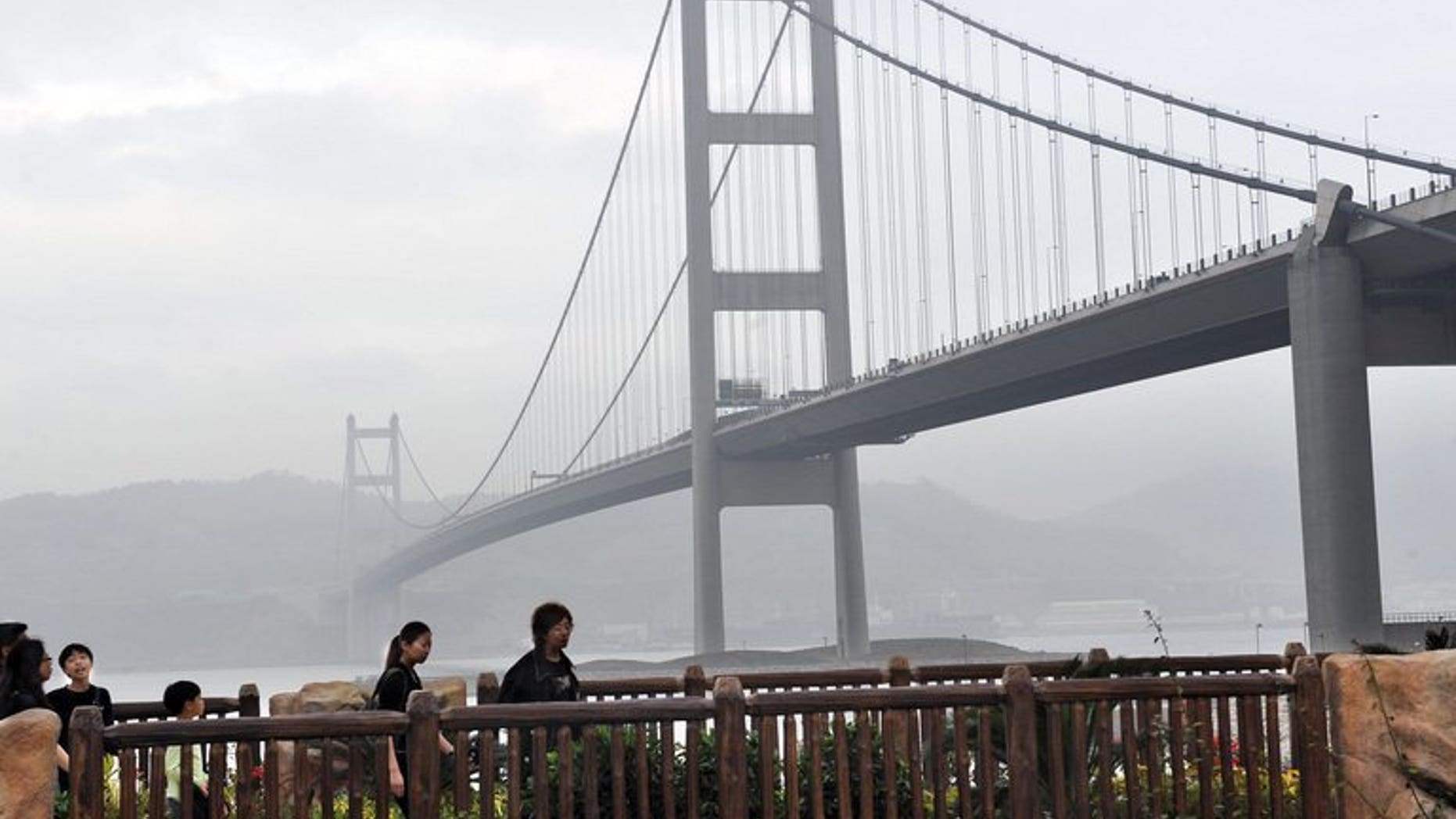 Visitors walk along a pathway near the Tsing Yi bridge in Hong Kong on February 15, 2009. Two people died and a third is missing after a boat sank in Hong Kong waters near the bridge Saturday, amid ongoing public concerns over the city's maritime safety following a fatal ferry crash last October.