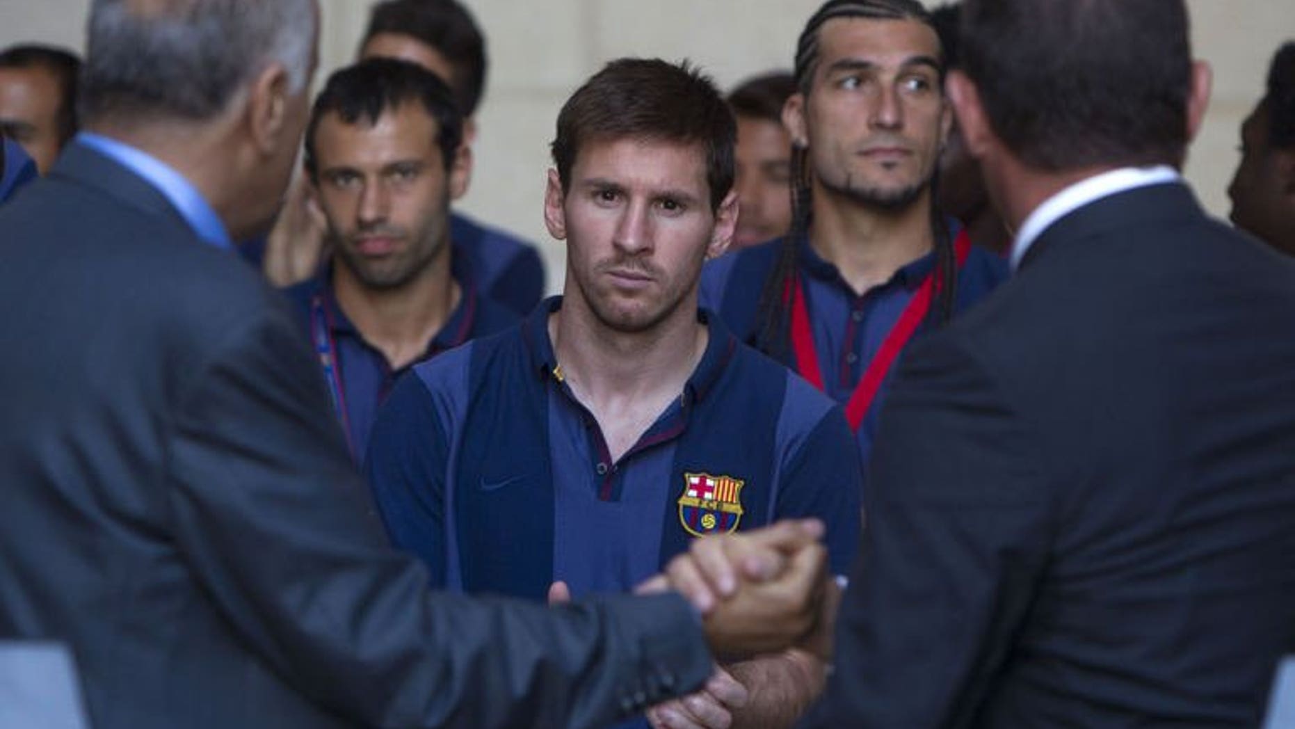 President of FC Barcelona Sandro Rosell (R) and president of the Palestinian Olympic Committee Jibril Rajub (L) shake hands in front of Argentinian forward Lionel Messi (C) at a joint news conference in the West Bank Biblical town of Bethlehem on August 3, 2013.