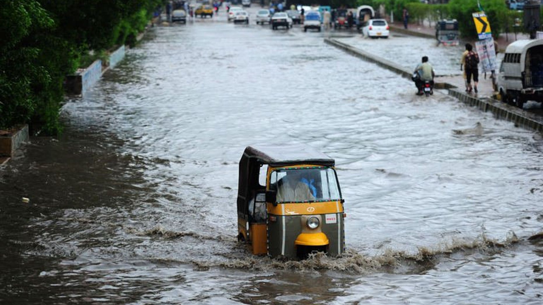 A Pakistani man drives his auto rickshaw along a flooded street after the rains in Karachi on August 3, 2013. At least 17 people were killed across Pakistan on Saturday after heavy monsoon rains caused flooding and roofs to collapse, officials said.