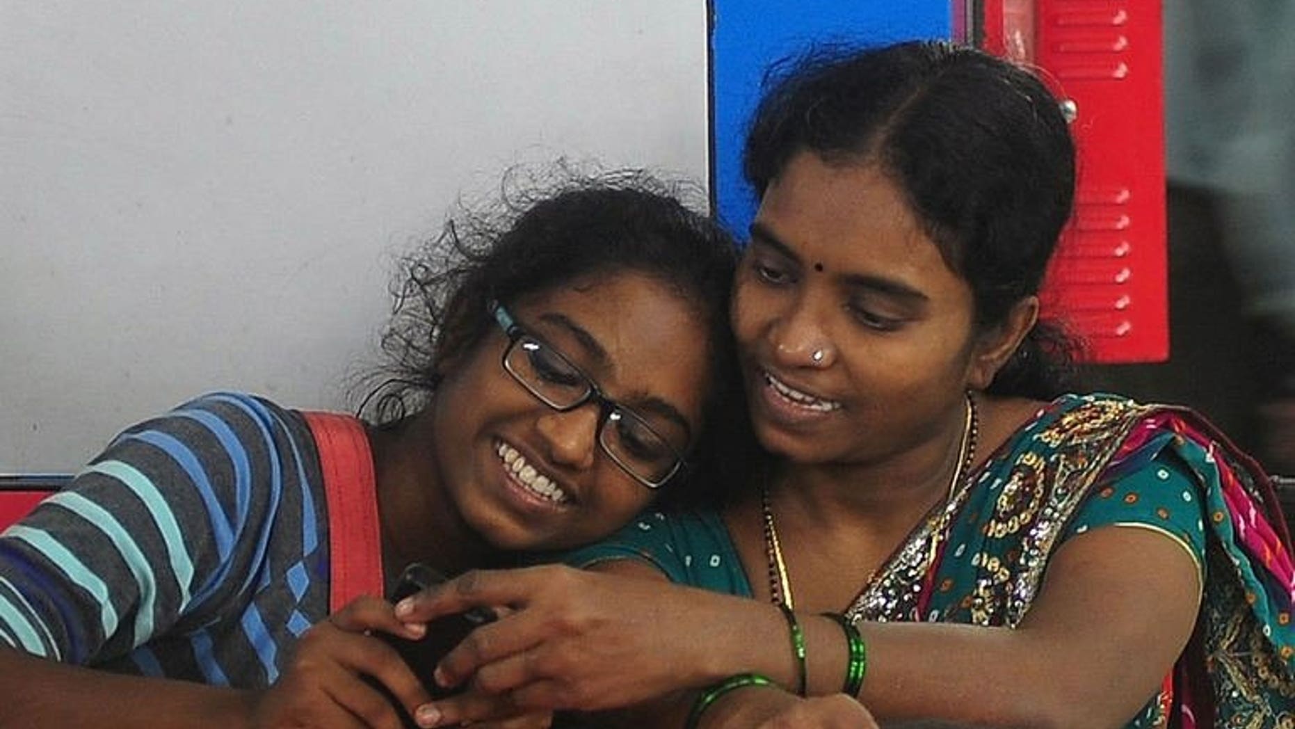 Shweta Katti (L) and her mother Vandana, pictured at a suburbun railway station in Mumbai, on July 30, 2013. Katti, 18, grew up in Mumbai's red-light district facing poverty and sexual abuse but, has overcome the odds to win a scholarship to study in New York, at the liberal arts Bard College, where she hopes to read psychology.