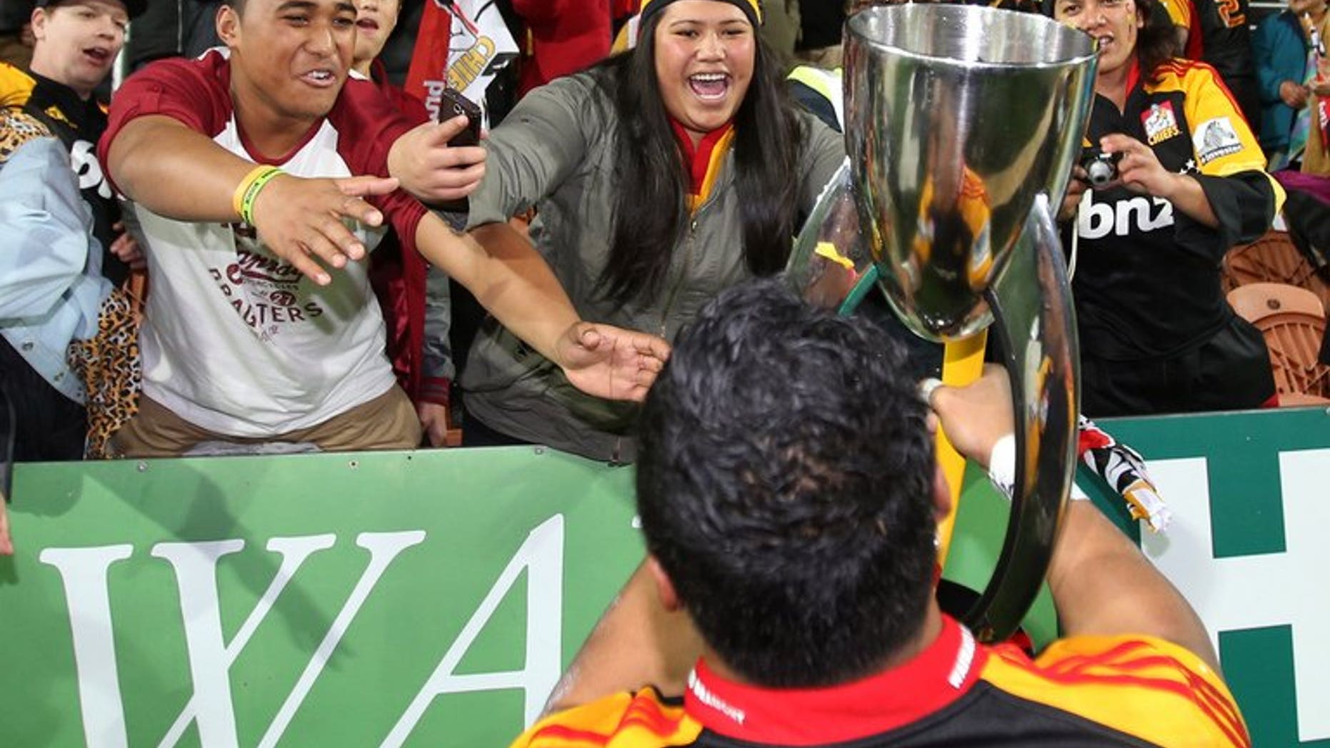 Bundee Aki of the Chiefs celebrates with the Super 15 trophy after defeating the ACT Brumbies on August 3, 2013.??Waikato Chiefs became Super Rugby champions with an attacking style.