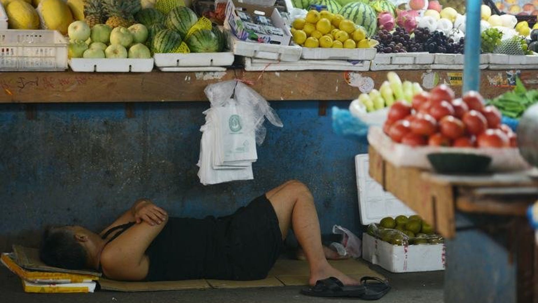 A vendor takes a rest in a market in Shanghai on July 15, 2013. A Chinese vendor's plan to fake his own death at the hands of social enforcers failed when he could not play dead long enough in scorching heat, state media reported Monday.