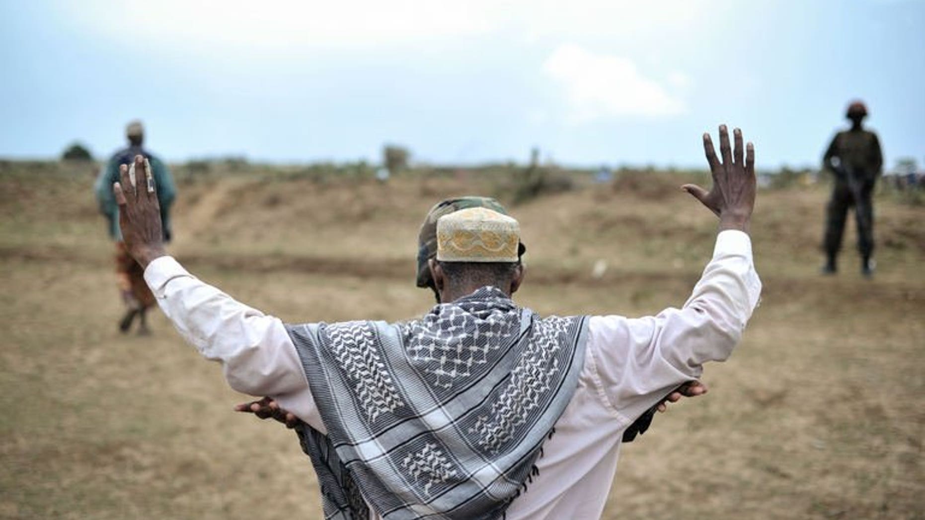 An AMISOM soldier conducts a security check on a Somali man at a food distribution center in Afgoye on August 4, 2013. Somalia's northeastern Puntland region said Monday it had cut all relations with the central government in Mogadishu, raising the prospect of further fractures to the already war-torn nation.