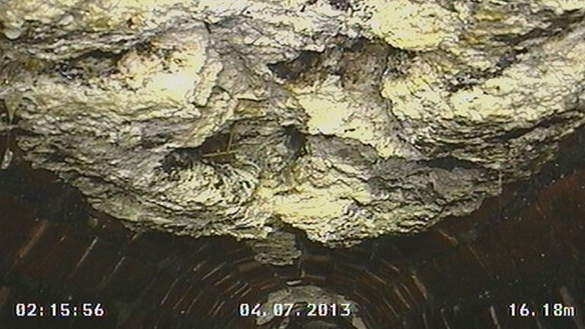 Picture taken on July 4, 2013 and released by waste management firm CountyClean Environmental Services shows a congealed ball of fat and waste in an underground sewer in Kingston, southwest London. The 15-tonne ball -- dubbed Britain's biggest ever 'fatberg' -- was removed from a London sewer after a 10-day operation following complaints from local residents that they couldn't flush their toilets.