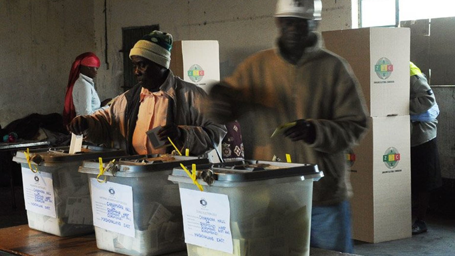 People cast their ballots at a polling station in Domboshava, 60km north of Harare, on July 31. A senior Zimbabwean election official said Tuesday he has resigned, just days after a colleague quit over the conduct of the vote that extended President Robert Mugabe's 33-year rule.