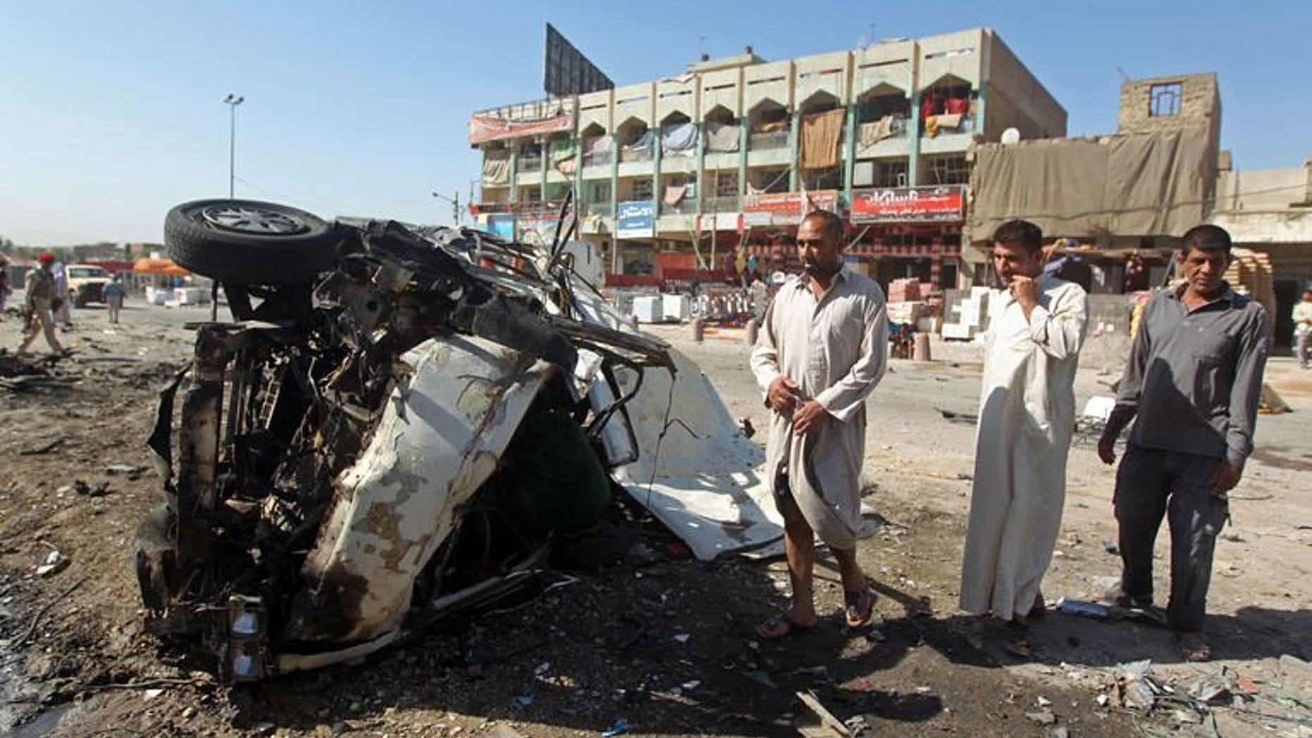 July 29, 2013 shows Iraqis inspecting the site of a car bomb explosion in the impoverished district of Sadr City in Baghdad. A series of apparently coordinated bombings struck Baghdad on Tuesday, killing 12 people, while five others died in violence elsewhere in Iraq, officials said.