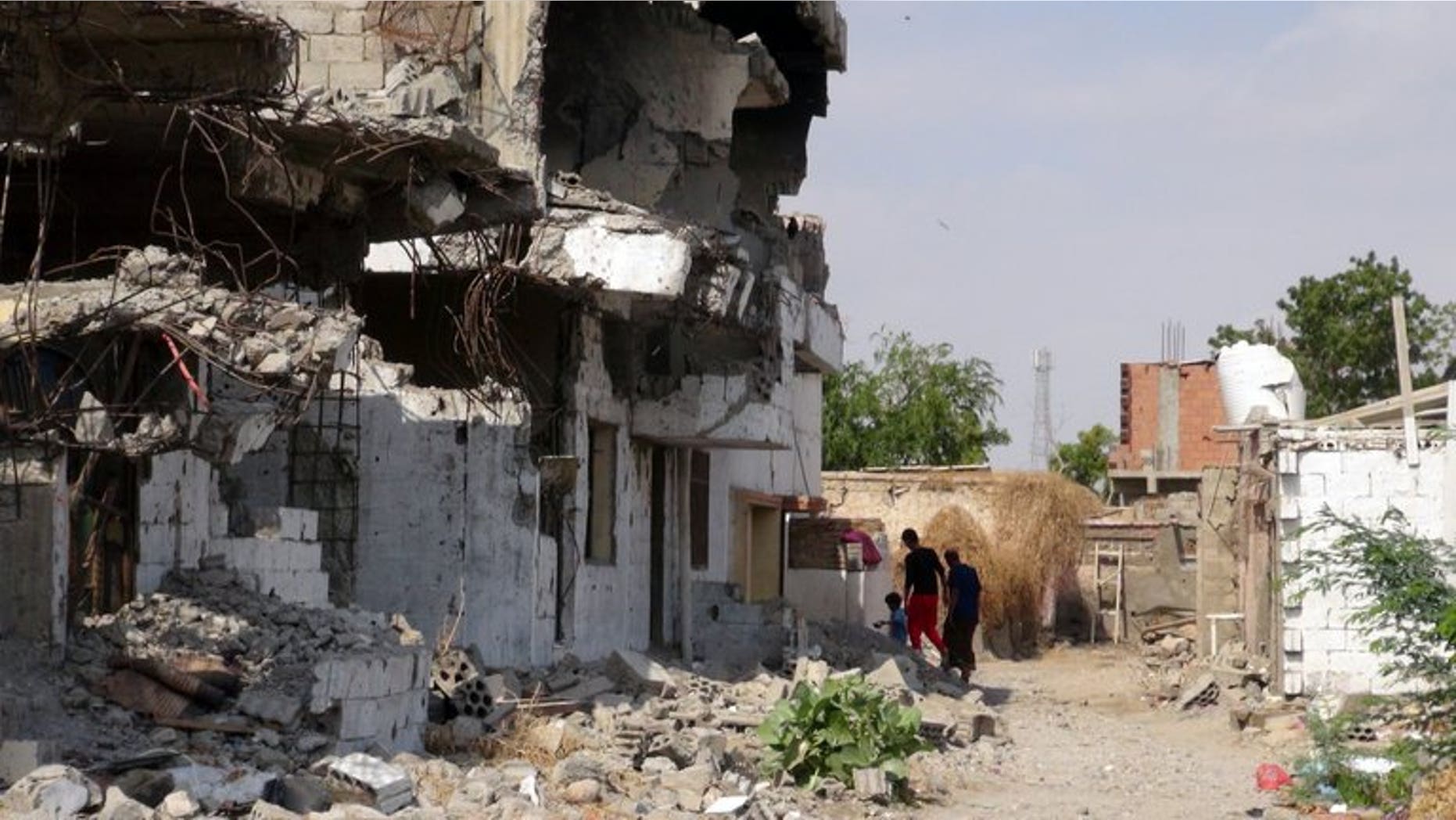 Yemenis walk past destroyed buildings in Zinjibar on December 5, 2012. Nasir al-Wuhayshi, a former aide to Al-Qaeda's late founder Osama bin Laden, tunnelled his way out of prison to become head of the Yemen-based Al-Qaeda in the Arabian Peninsula.