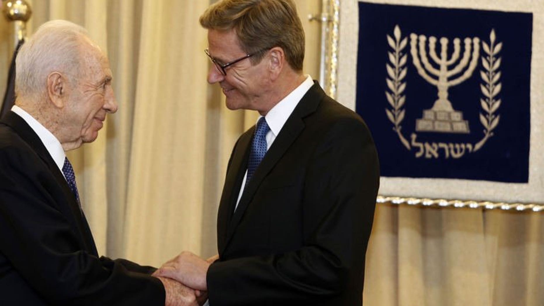 German Foreign Minister Guido Westerwelle (R) is greeted by Israeli President Shimon Peres (L) at the presidential residency in Jerusalem on August 11, 2013. Westerwelle met Sunday with Israeli officials on a visit to support nascent peace talks, offering to try to soften a European ban on dealings with Jewish settlements.