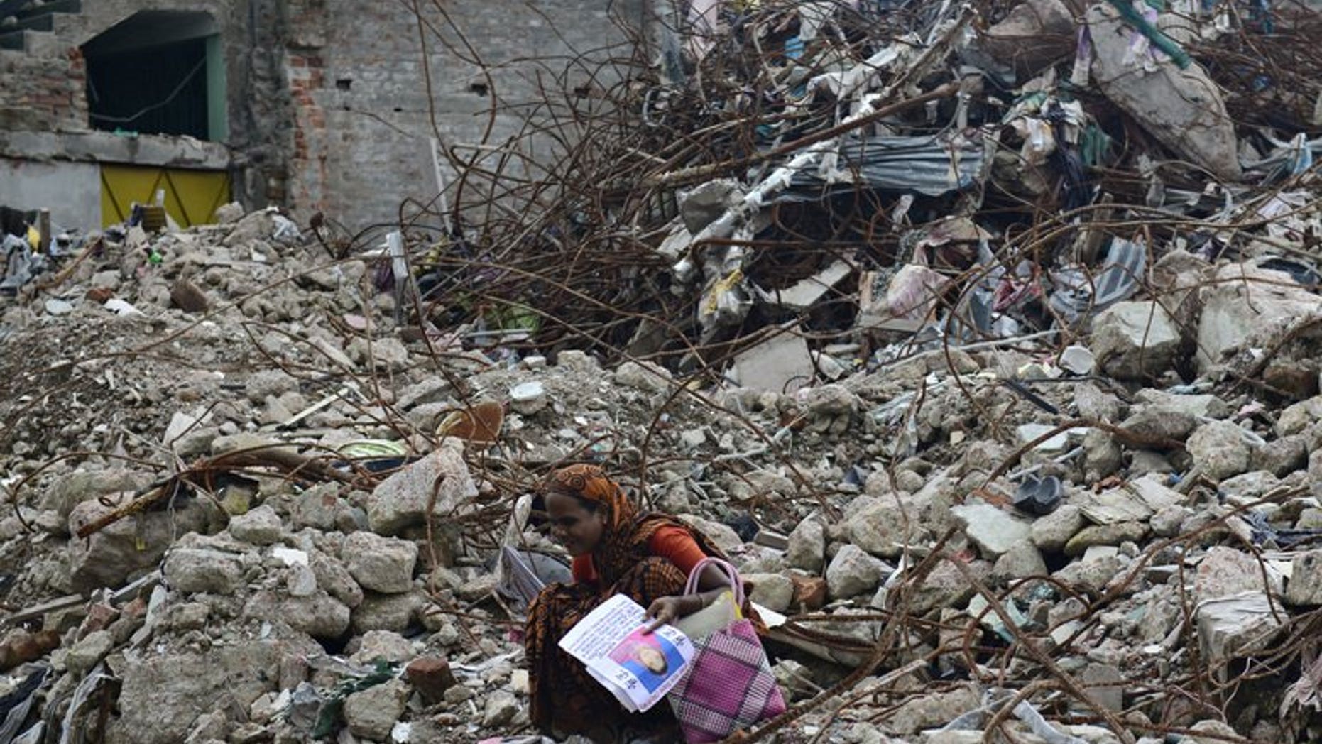 A mourner grieves for her relative, missing and presumed dead, at the scene of the April 24 Rana Plaza garment building collapse on the 100-day anniversary of the disaster in Savar, on the outskirts of Dhaka, on August 2, 2013. A Bangladeshi garment worker who spent 108 days in a coma after being badly injured in one of the world's worst industrial disasters has died, officials said on Monday.