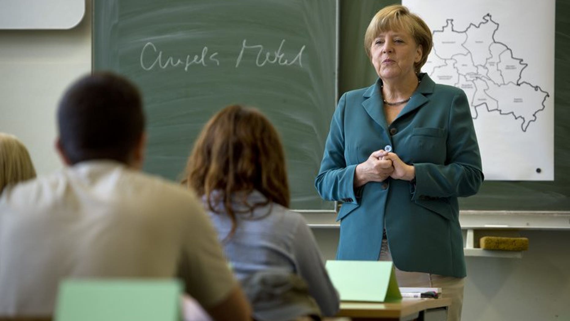 German Chancellor Angela Merkel talks to students during her visit to the Heinrich Schliemann secondary school in Berlin, on August 13, 2013. Merkel, campaigning for a third term, filled in as a school history teacher on the 52nd anniversary of the building of the Berlin Wall.