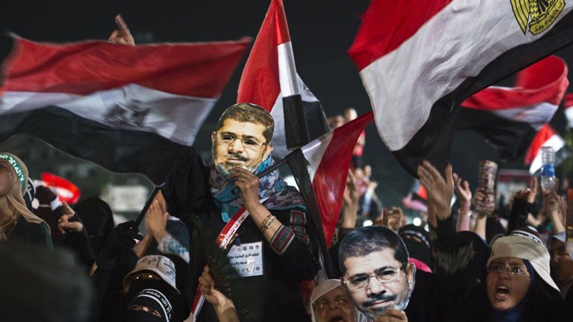 Female members of the Muslim Brotherhood hold up masks of Egypt's ousted president Mohammed Morsi as they take part in a sit-in protest outside the Rabaa al-Adawiya mosque in Cairo, on August 12, 2013. Egyptian police have fired tear gas to break up clashes between supporters of Morsi and residents of a central Cairo neighbourhood, AFP correspondents said.