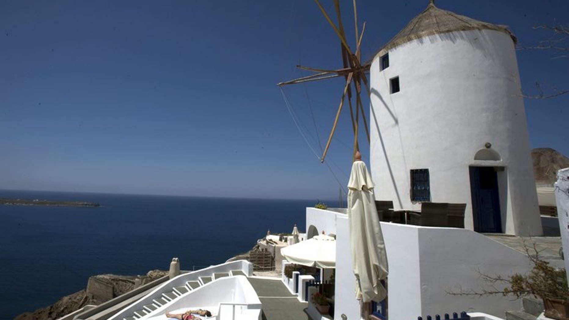 A photo taken on April 24, 2008 shows tourists sunbathing on the Greek island of Santorini. The Greek island of Santorini -- one of the country's premier travel destinations -- has been hit with a sweeping power shortage after a fire at the island's main electricity plant.