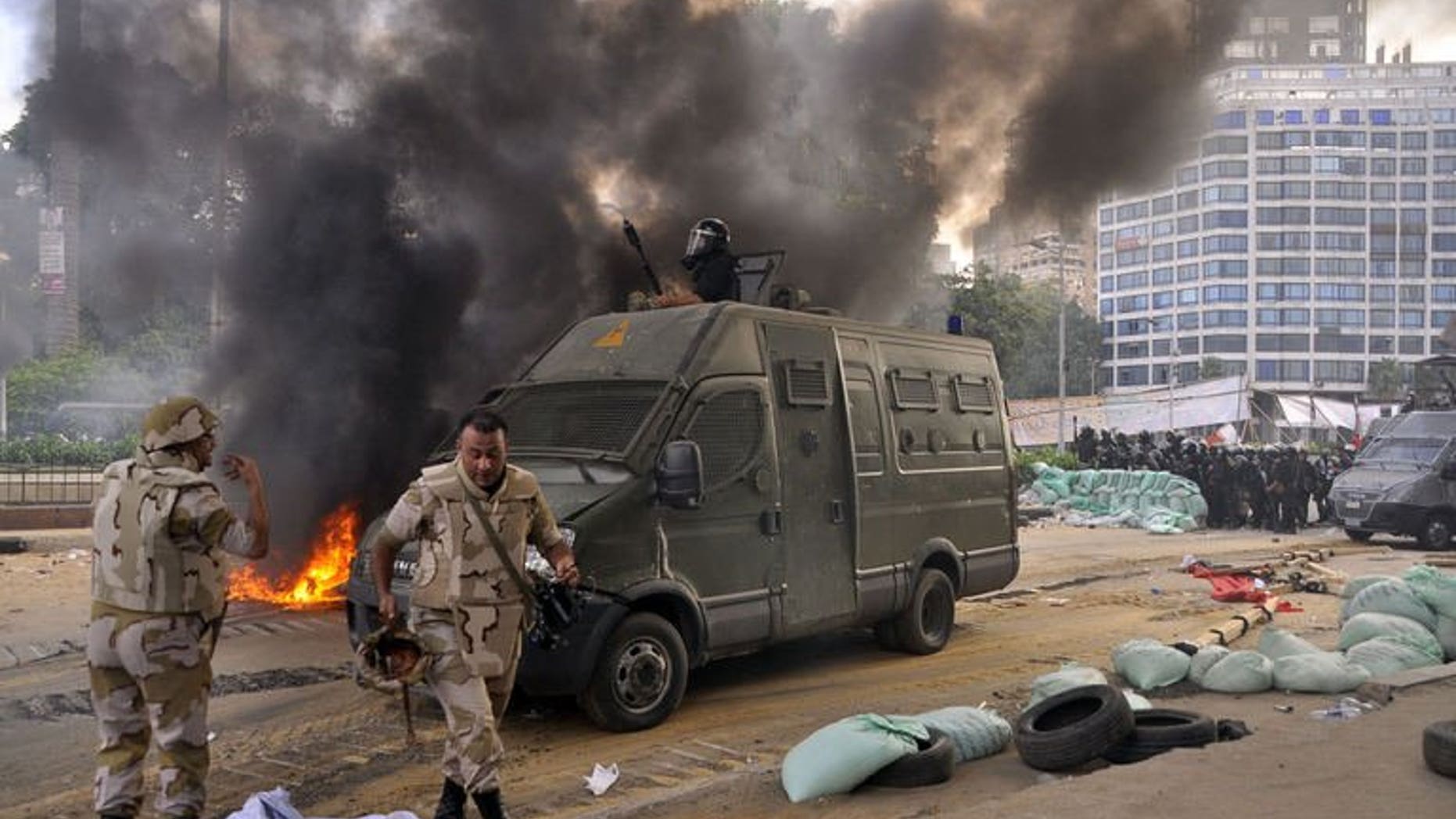 Egyptian riot police disperse a huge protest camp set up by supporters of ousted president Mohamed Morsi near Al-Nahda Square in Cairo, on August 14, 2013.