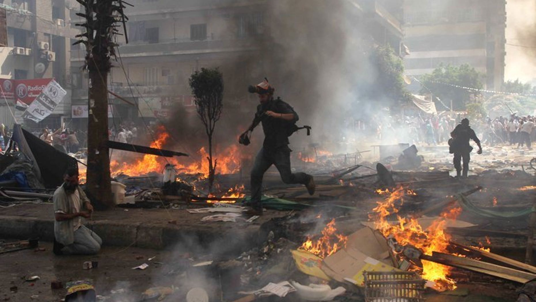 Reporters run for cover during clashes between Muslim Brotherhood members and police in Cairo on August 14, 2013. Egypt declared a month-long state of emergency as violence raged across the country following a crackdown on supporters of ousted president Mohamed Morsi.