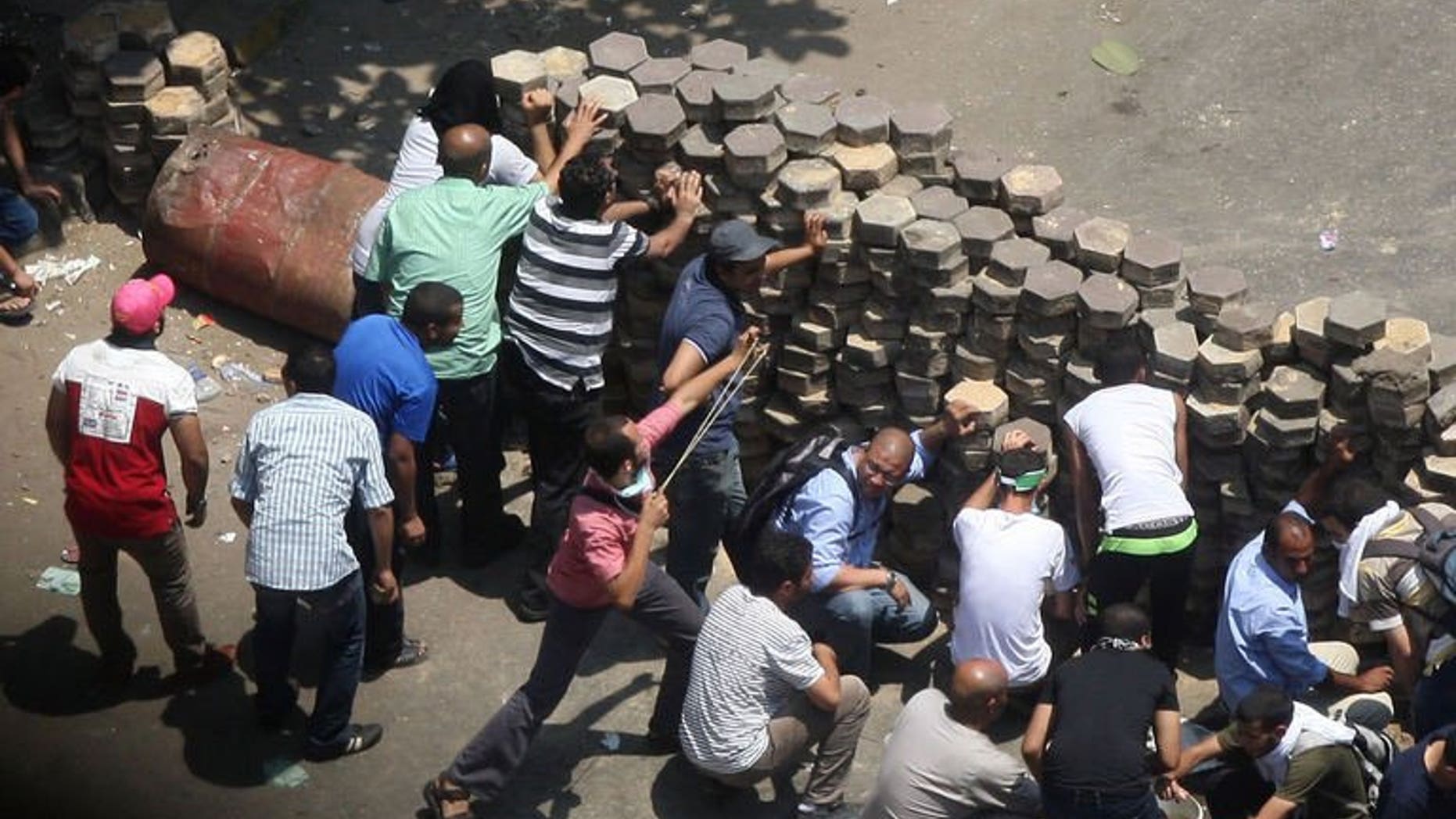 Egyptian supporters of ousted president Mohamed Morsi confront riot police at Mustafa Mahmoud Square in Cairo, on August 14, 2013. Egypt's government has declared a curfew in Cairo and 10 other provinces in a bid to contain nationwide violence following a crackdown on Morsi's supporters.