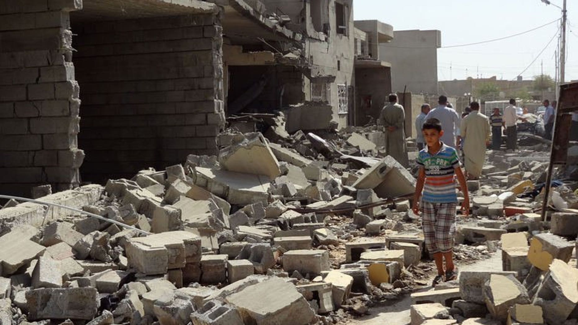 Iraqis inspect the remains of houses after a suicide bomb the day before, on August 11, 2013 in the city of Tuz Khurmatu. Prime Minister Nuri al-Maliki has vowed that security forces will keep up a campaign of mass arrests and targeting of militant camps to counter Iraq's worst outbreak of violence since 2008.