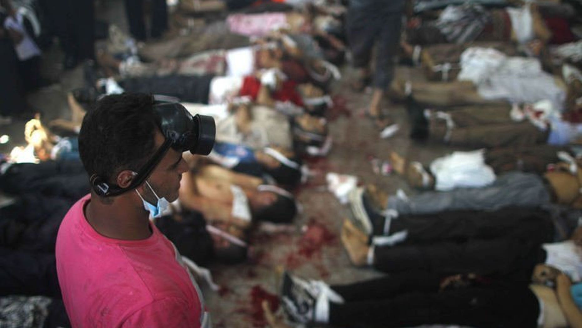 A man looks at bodies laid out in a make shift morgue after Egyptian security forces stormed two huge protest camps at the Rabaa al-Adawiya and Al-Nahda squares where supporters of ousted president Mohamed Morsi were camped, in Cairo, on August 14, 2013.