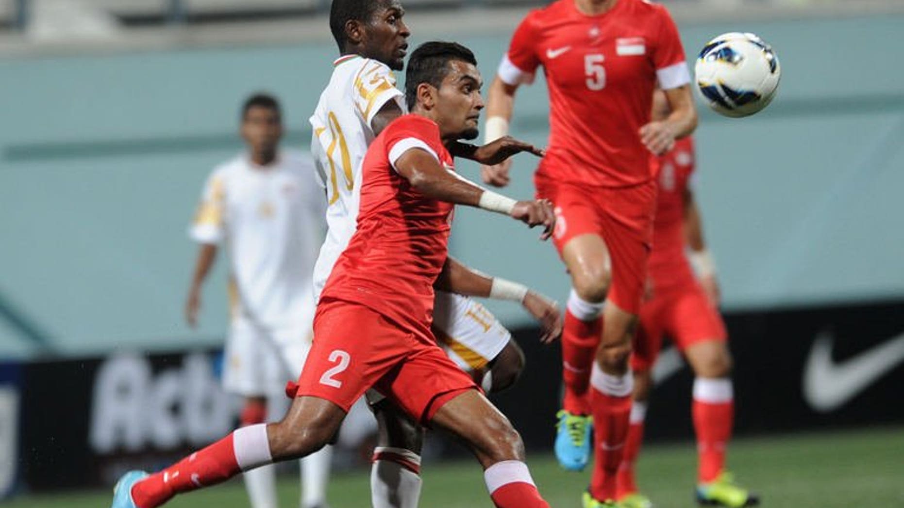 Oman midfielder Qasim Said (R) and Singapore defender Muhammed Faritz (L) fight for the ball during the AFC Cup Australia 2015 qualifiers in Singapore on August 14, 2013. Oman won 2-0.