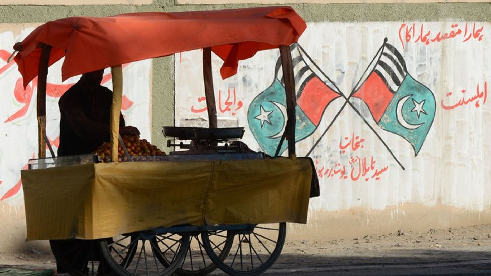A Pakistani vendor waits for customers near grattifi messages and scrawled flags of Jihad and Ahle Sunnat Wal Jamaat, the "political wing" of a banned militant faction Lashkar-e-Jhangvi in Quetta on March 5, 2013. Pakistan will hang two convicted militants next week, officials said, despite a Taliban warning that it would regard the execution of any of its members as a "declaration of war".
