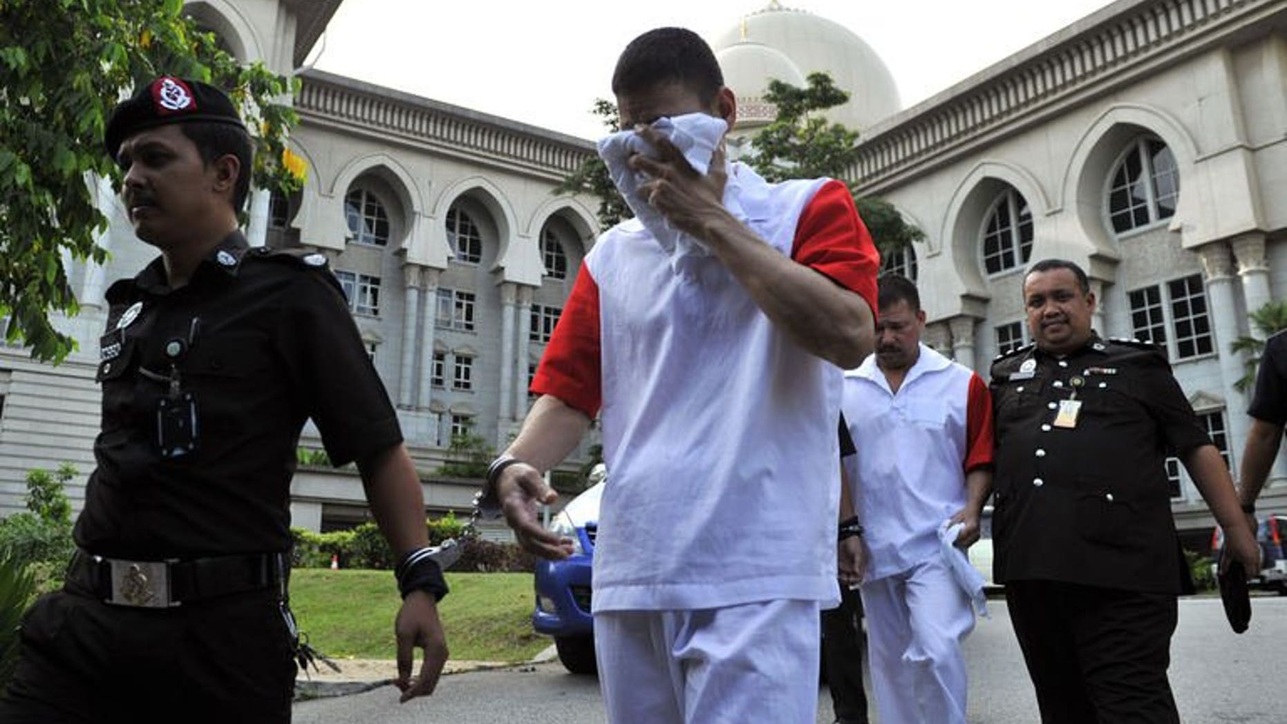 Malaysian prison personnel escort Mexican brothers Jose Regino Gonzalez Villarreal (2nd L) and Luis Alfonso Gonzalez Villarreal (2nd, R) as they leave the appeals court in Putrajaya on August 14, 2013. Malaysia's appeals court upheld the decision to hang three Mexican brothers to death for drug trafficking, forcing them to head to the nation's apex court as a last resort.