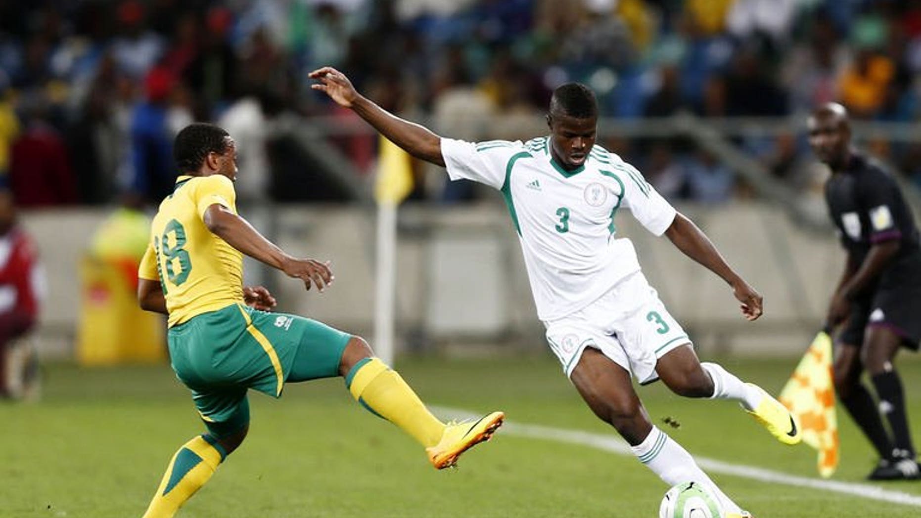 Nigeria's Elderson Echiejile (R) passes the ball away from South Africa's Thuso Phala during the 2013 Nelson Mandela football Challenge friendly match between South Africa and Nigeria at Moses Mabhida Stadium on August 14, 2013 in Durban, South Africa. Nigeria won 2-0.