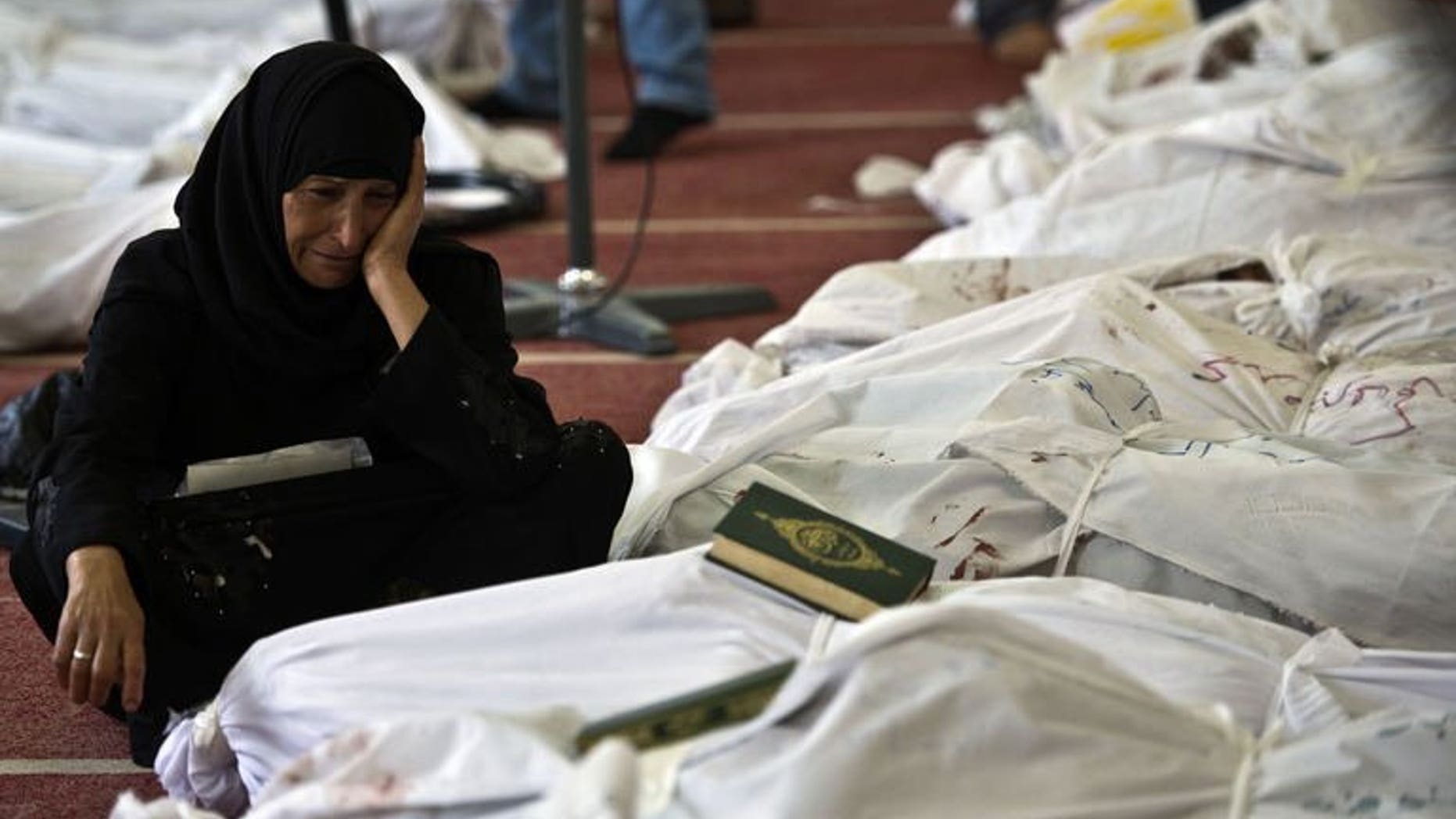 An Egyptian woman mourns over the body of her daughter wrapped in shrouds at a mosque in Cairo, on August 15, 2013. Egypt's Muslim Brotherhood has called for a march in Cairo, a day after bloody crackdown on its supporters who occupied protest camps demanding the reinstatement of president Mohamed Morsi.
