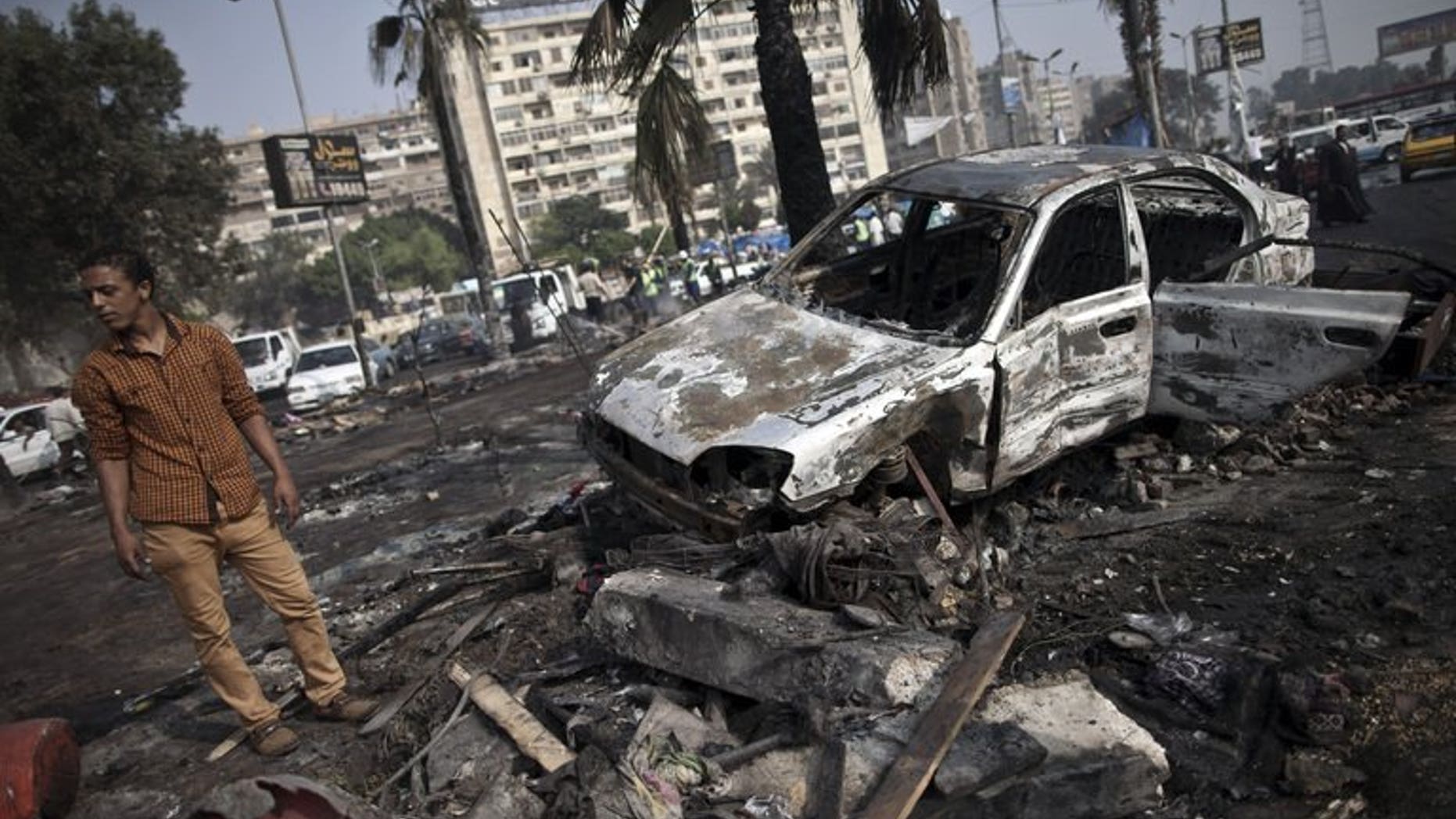 A man stands amidst the debris at Rabaa al-Adawiya square in Cairo on Thursday. Britain has summoned Egypt's ambassador to express its "deep concern" at the violence in the country and urged the authorities to act with "the greatest restraint", the Foreign Office said on Thursday.