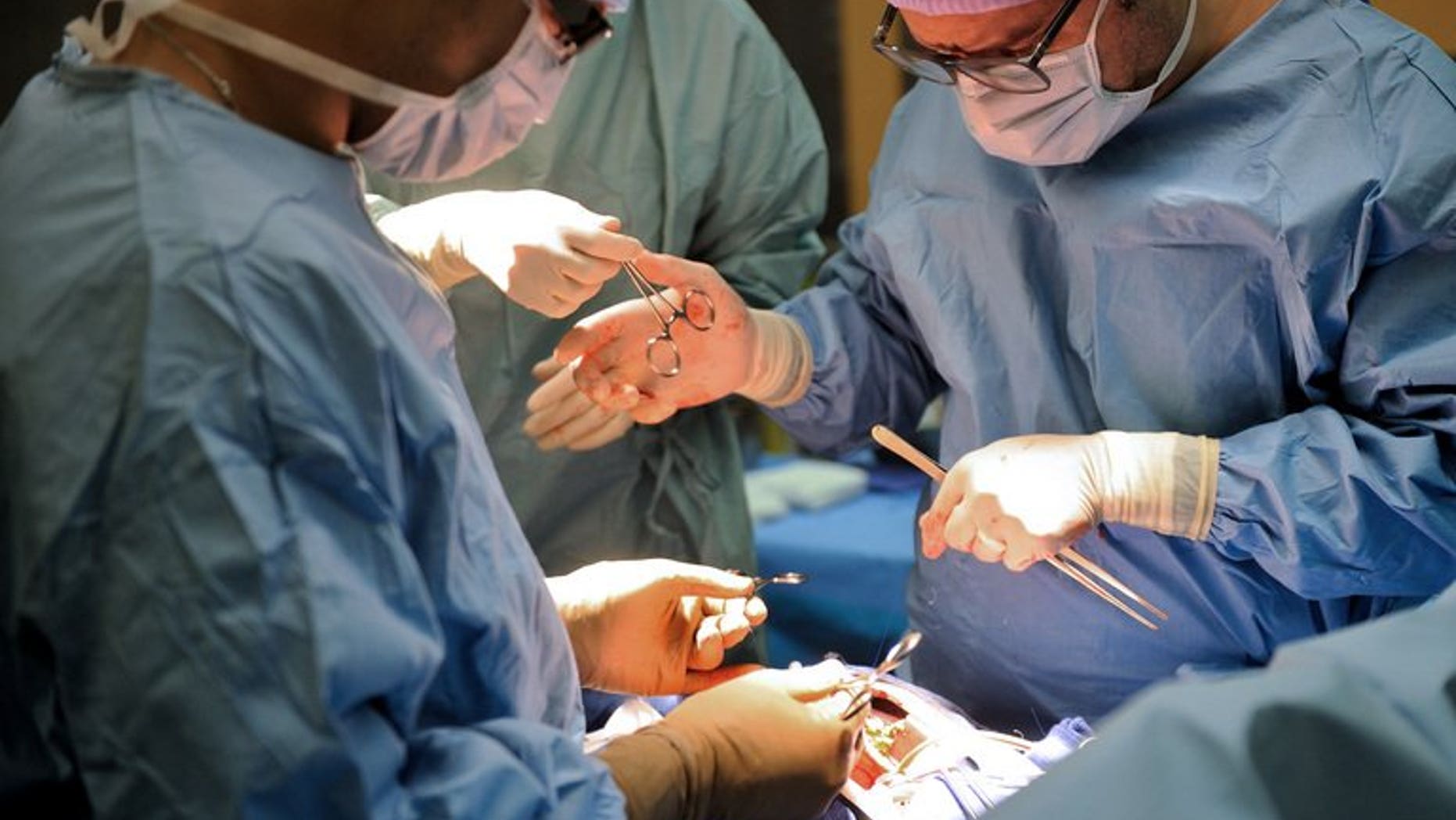 Surgeons operate at the Cardiology Hospital in Lille, northern France. The British government is lifting a ban on staff with HIV working in the state-run National Health Service from carrying out certain procedures on patients.