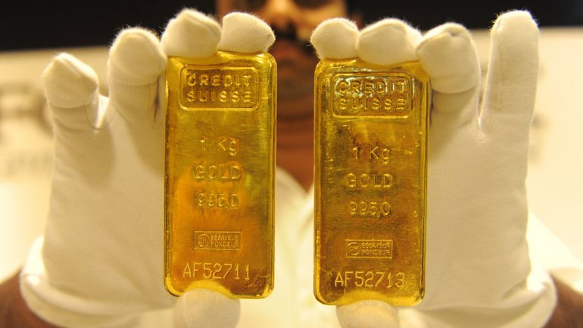 A jewellery shop employee displays 24-carat gold bars in Ahmedabad on August 20, 2011. Global demand for gold fell to a four-year-low in the second quarter despite a surge in demand from India and China as the metal became cheaper, the World Gold Council said Thursday.