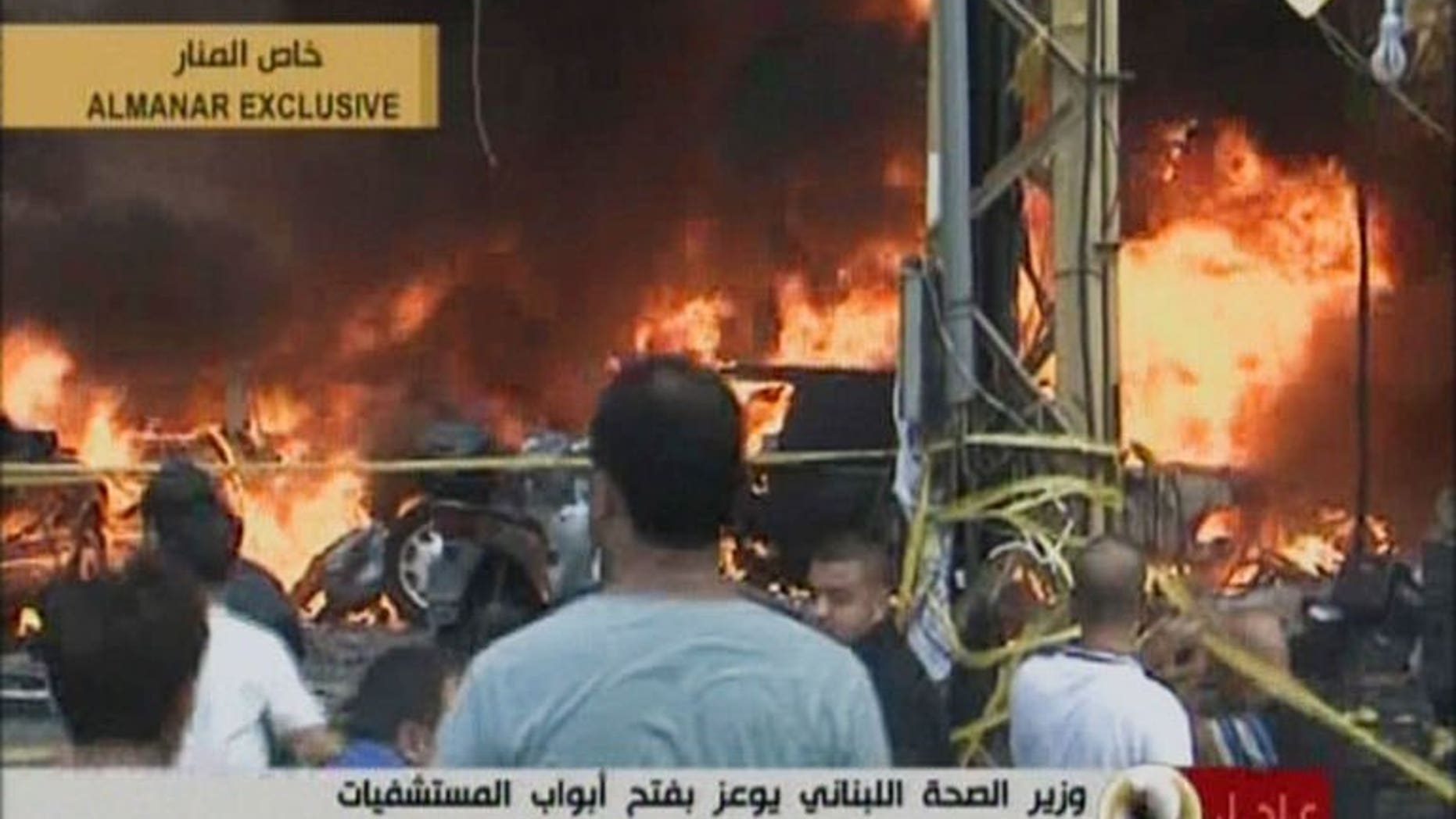 An image grab from Hezbollah's al-Manar TV shows Lebanese gathering at the scene of a car bomb in the majority Shiite southern suburb of Beirut on August 15, 2013.