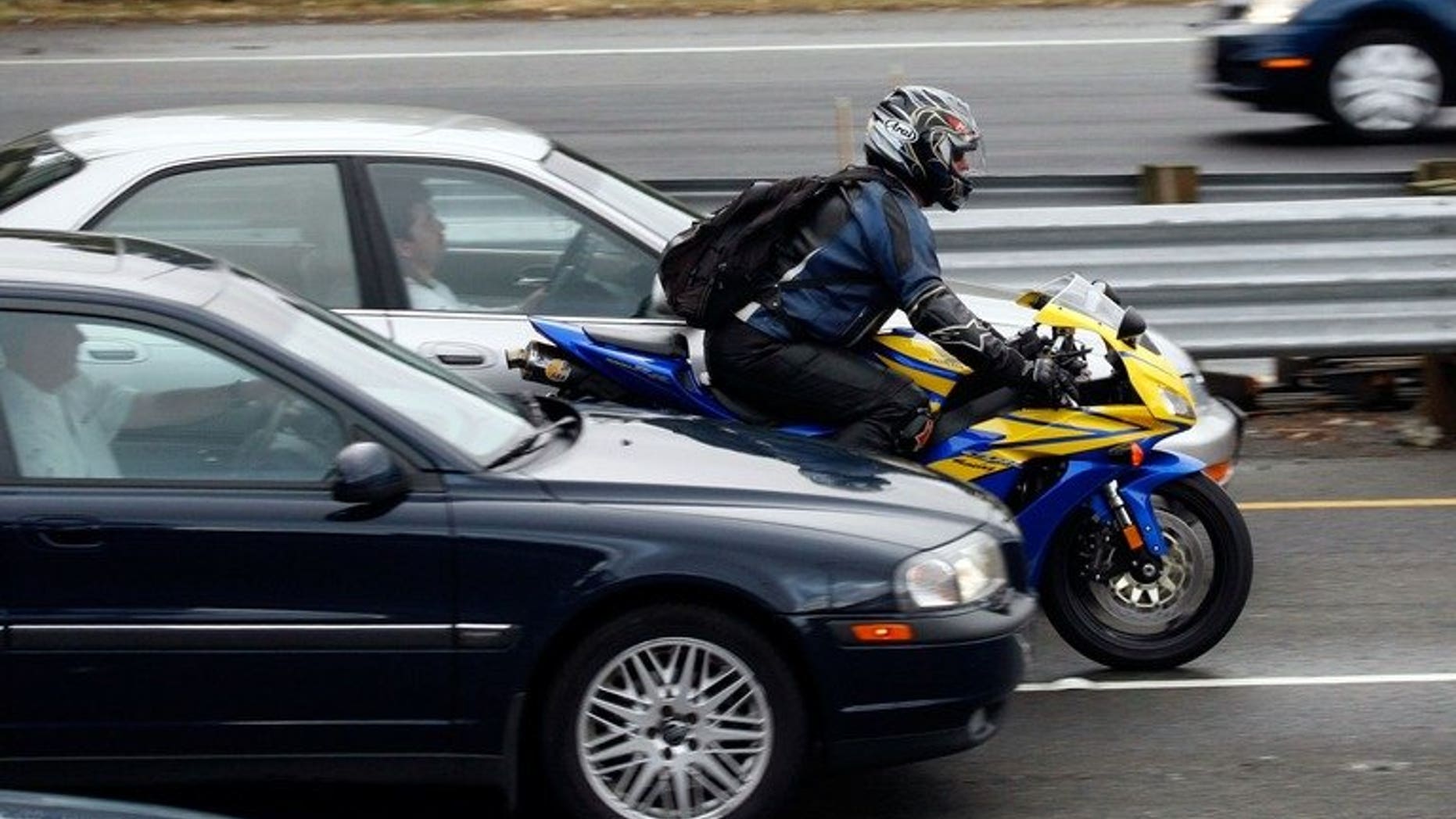 A motorcyclist rides between cars in slow moving traffic on Highway 101 on 16 October 2007 in Corte Madera, California. A Canadian man faces several charges and Can$1,200 in fines after speeding past police with a video camera on his motorcycle that recorded his bad driving, authorities said Thursday.