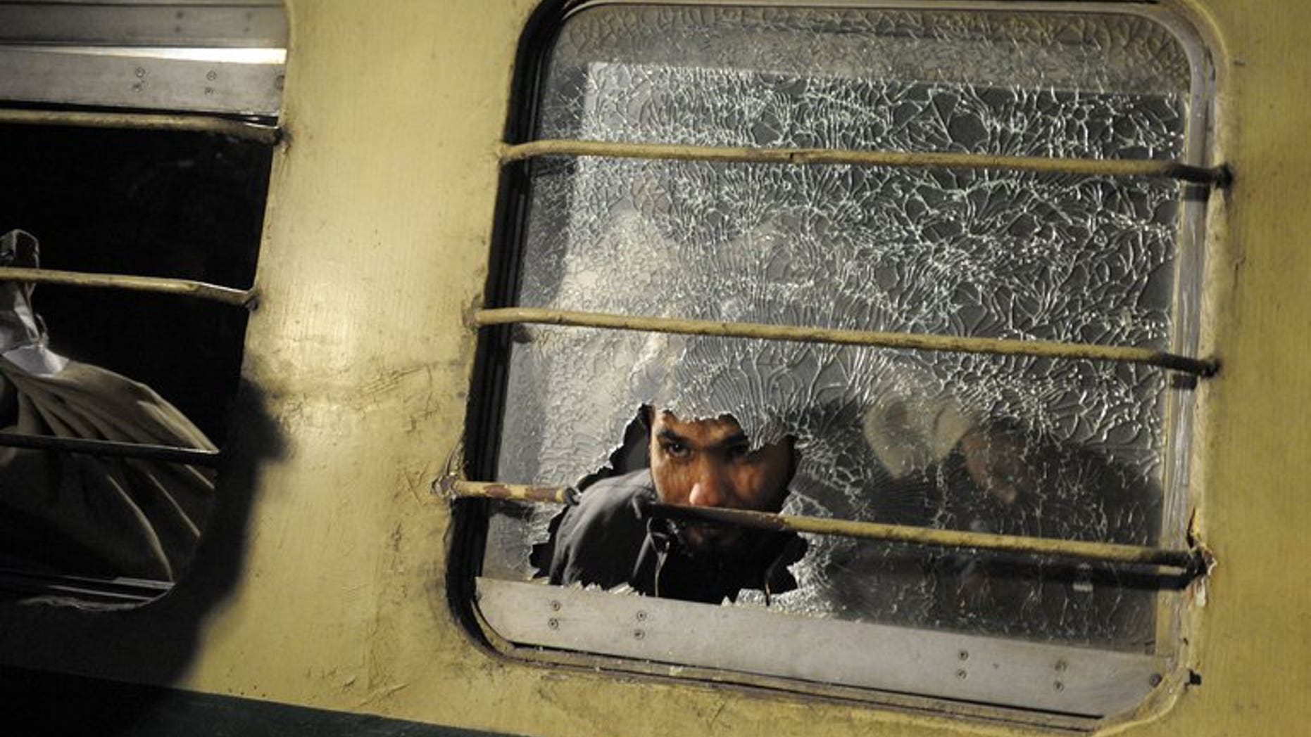 A man looks through a broken mirror on a train after an attack at a railway station in Quetta last year. Unidentified militants killed two people and wounded 24 Friday in a gun and rocket attack on a passenger train in restive southwest Pakistan, officials said.