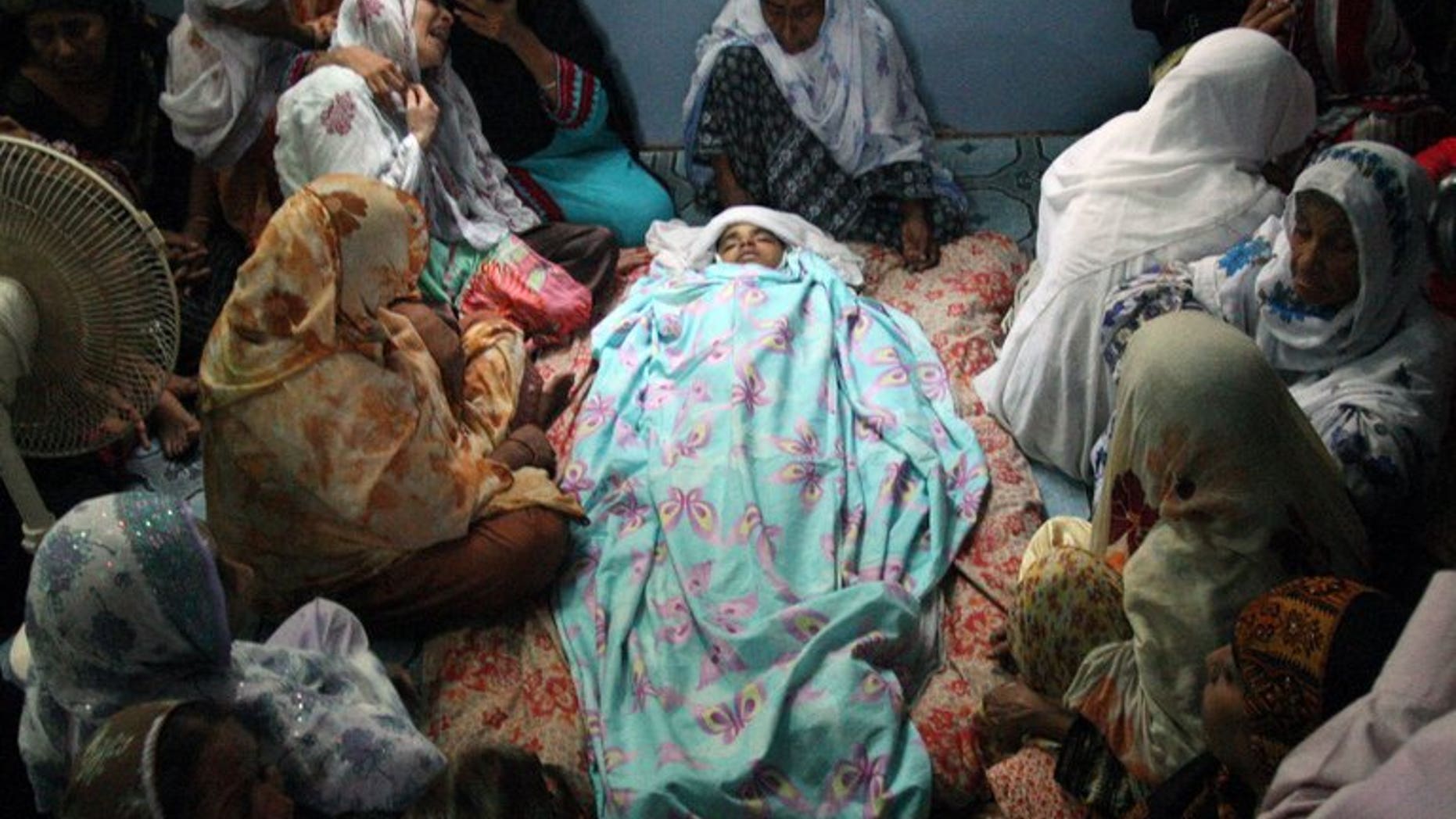 Pakistani mourners gather around the body of Abdul Basit, who was killed in a bomb blast in Karachi on August 7, 2013. Pakistan's football chief Friday said he was confident about hosting qualifying matches for the AFC's under-16 championship despite a bomb attack that killed eight young football fans, including Basit, in Karachi last week.