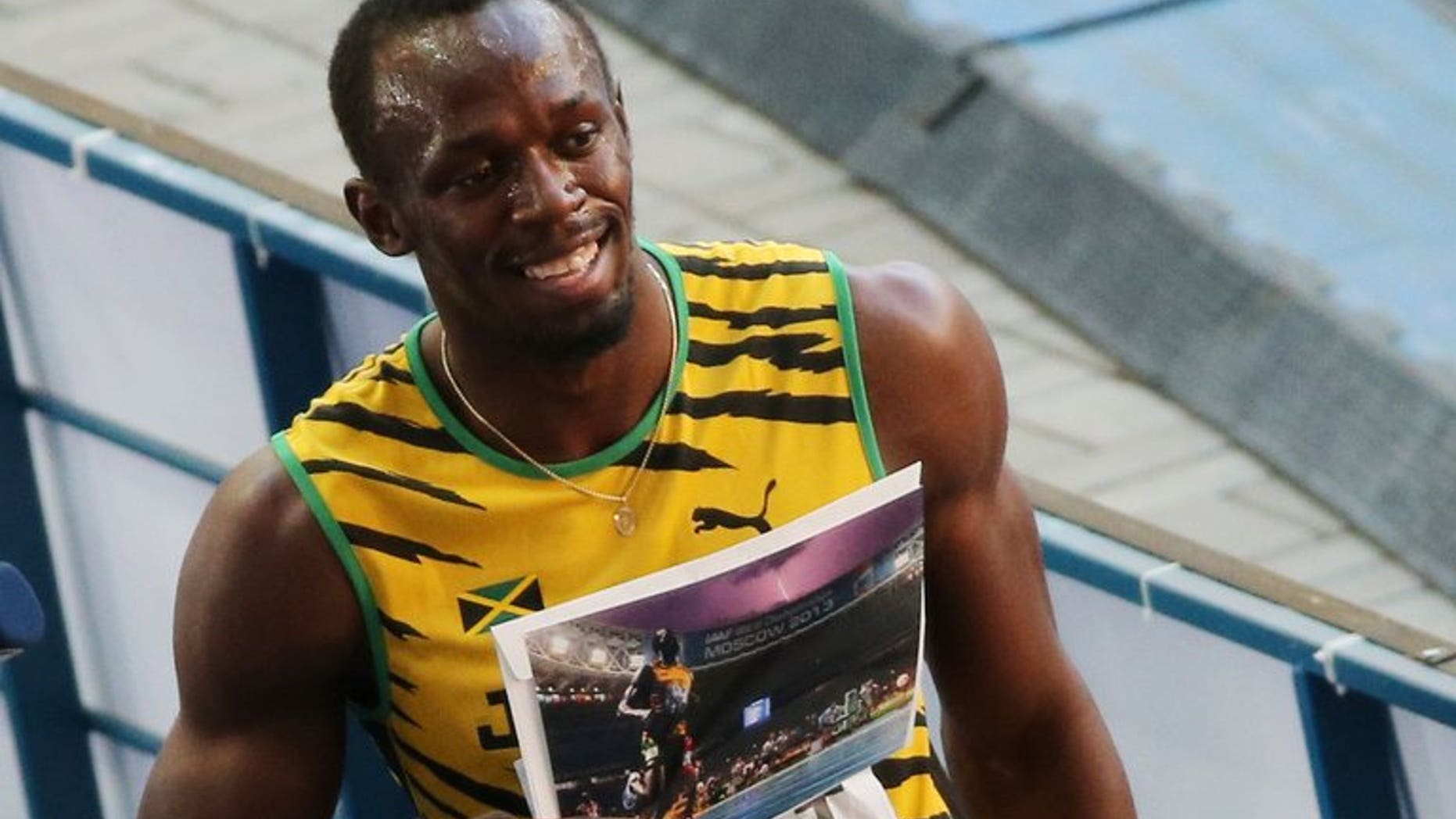 Jamaica's Usain Bolt poses with an AFP picture by photographer Olivier Morin after the men's 200 metres semi-final at the 2013 IAAF World Championships at the Luzhniki stadium in Moscow on August 16, 2013.
