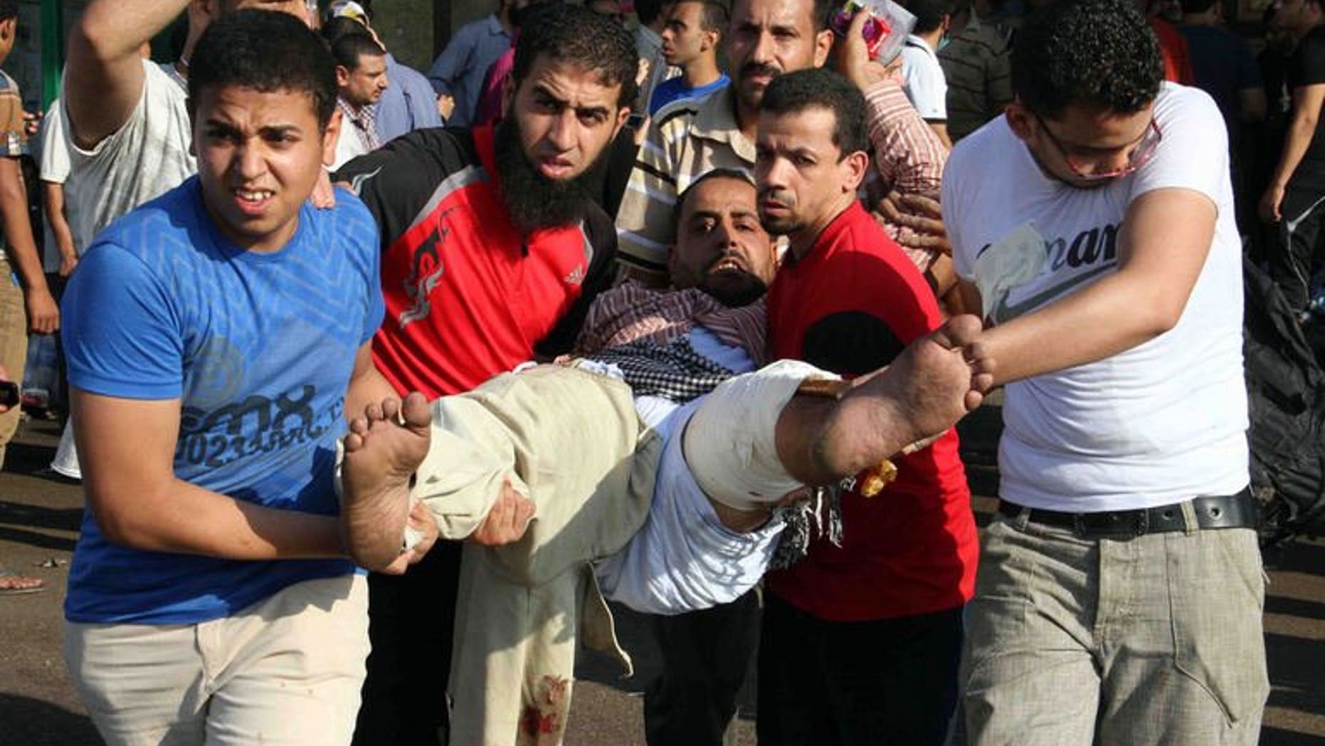 Egyptian Muslim Brotherhood supporters carry a wounded comrade near Ramses square in Cairo on August 16, 2013. France and Britain called Friday for Europe to send a strong message on the escalating crisis in Egypt, urging the EU to review its relations with Cairo.