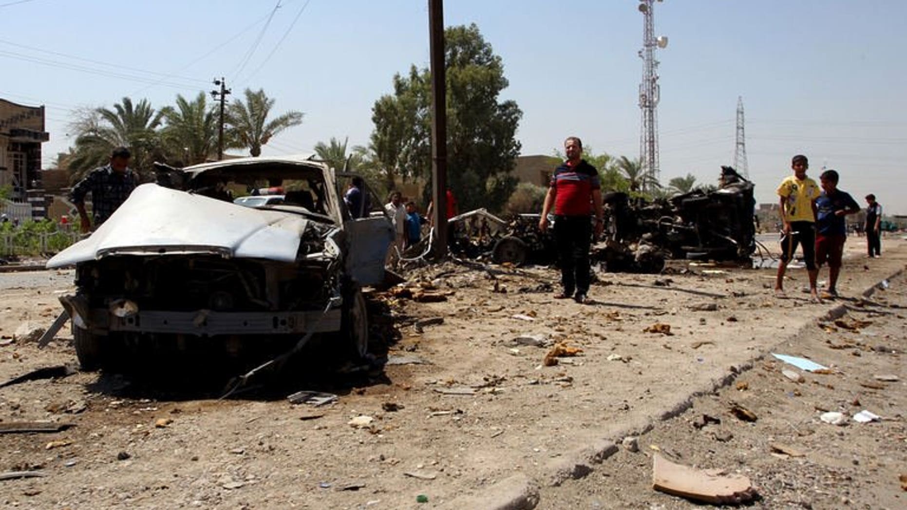 Iraqis inspect the scene of a car bomb attack near the office of Al-Ahad television channel in Baghdad's eastern neighbourhood of Baladiyat on August 15, 2013. Attacks in Baghdad and north of the capital killed seven people on Friday, the latest in spiralling violence authorities have failed to stem despite launching wide-ranging anti-militant operations.