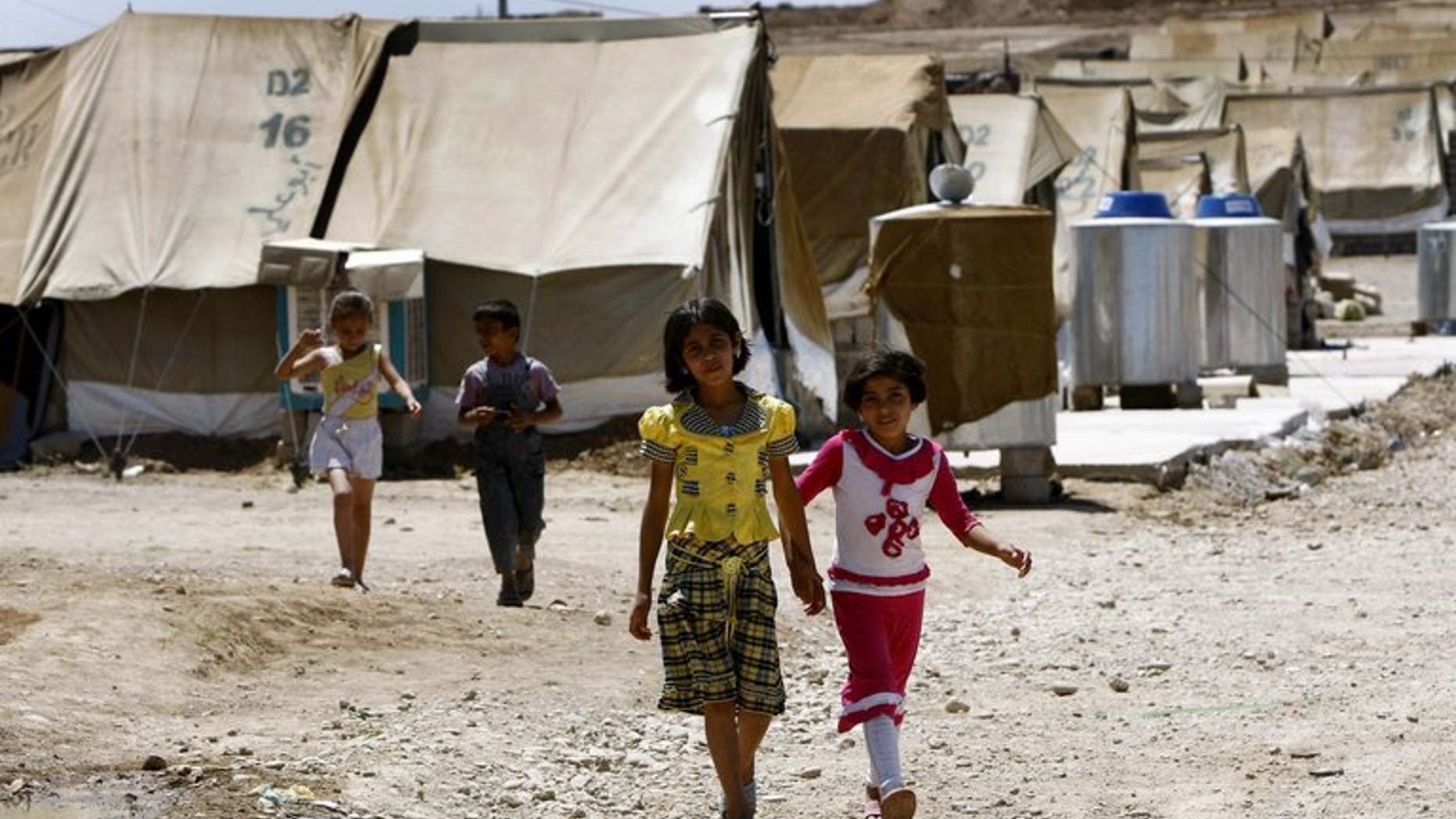 Syrian-Kurdish children walk on June 8, 2012 in the Domiz refugee camp, 20 km south-east of Dohuk city. The UN refugee agency said Friday it was scrambling aid in northern Iraq after thousands of Syrians crossed the tightly-controlled border in a sudden and unexplained influx.