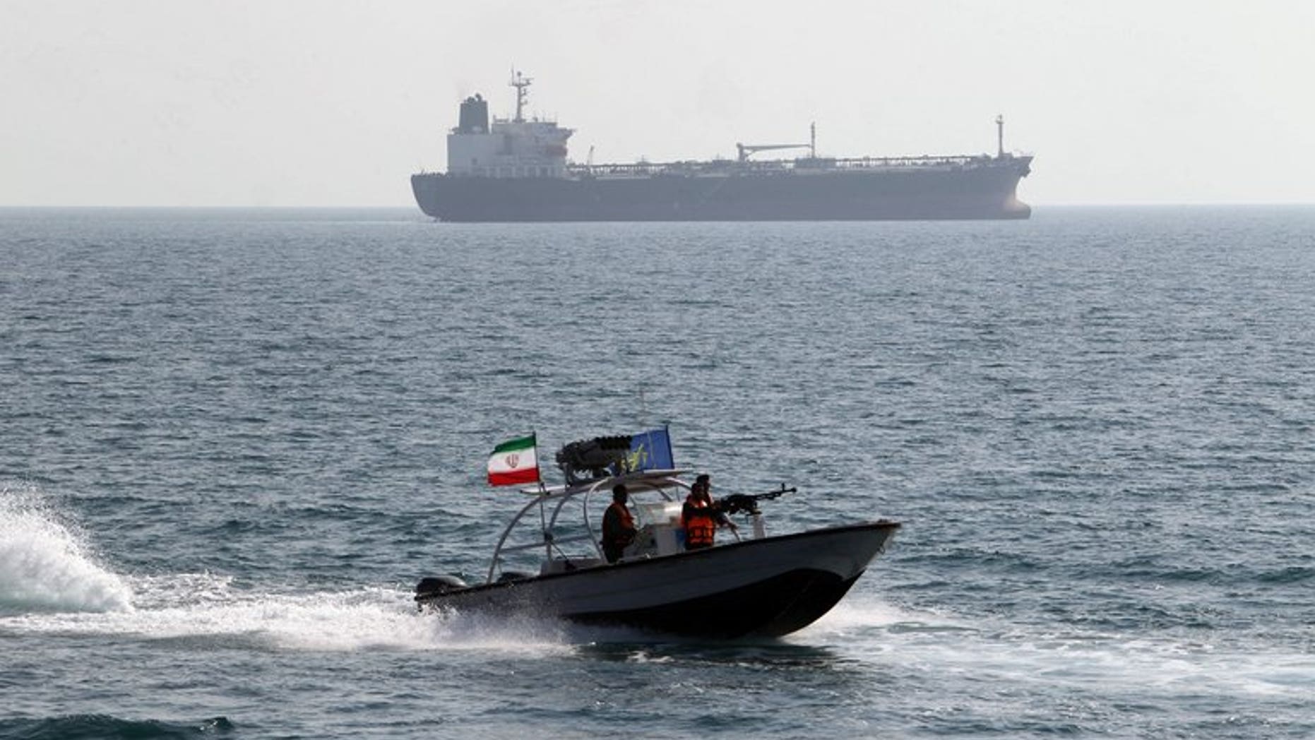 Iranian Revolutionary Guards drive a speedboat in front of an oil tanker at the port of Bandar Abbas on July 2, 2012. New Delhi and Tehran were Saturday working to resolve a dispute over the detention of an Indian oil tanker by Iranian naval guards for allegedly polluting sea waters in the Persian Gulf.