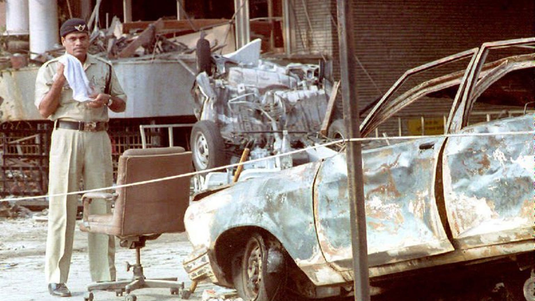 An Indian police officer stands beside a charred automobile outside the Air India building in Mumbai on March 14, 1993 after a series of bombings. Indian police said Saturday they had arrested a top member of a banned militant outfit accused of helping mastermind over 40 deadly bomb attacks across the country, including the 1993 Mumbai blasts.